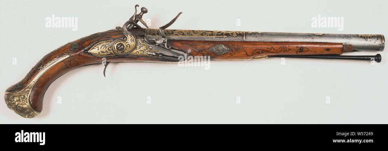 Equestrian pistol with flint lock, the iron round barrel, decorated with copper ornaments over the entire length, ends octagonal. Flint lock is entirely of iron with copper ornaments, the top of the rooster is also decorated with a copper ornament, the flint is ribbed. The wooden drawer is decorated with motifs through burned lines and has inlaid silver ornaments. The wooden stock has a copper plate decorated with copper from rocaille work. The neck of the flask is ornamented with thin lines of brass that run in graceful forms over the entire length of the neck. The trigger guard is missing, a Stock Photo