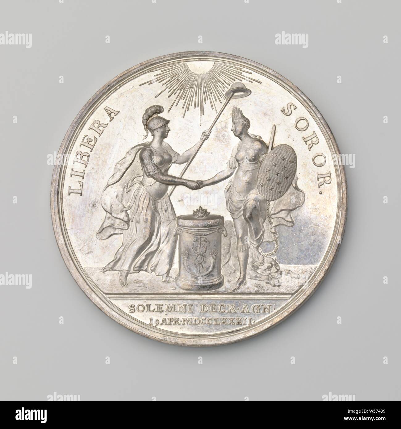 Recognition of the Independence of the United States of America by the States General of the United Netherlands, Silver commemorative medal. Obverse: lit by celestial light, the personification of the Netherlands, depicted as a helmeted woman, and the personification of America, depicted as a woman with feather headdress, sword and shield with thirteen stars, shaking hands with each other above a burning altar, The Netherlands ceases to be a spear of freedom hat over America's head, which chain, with which it was attached to a leopard lying at its feet, has broken within the scope, cut off Stock Photo