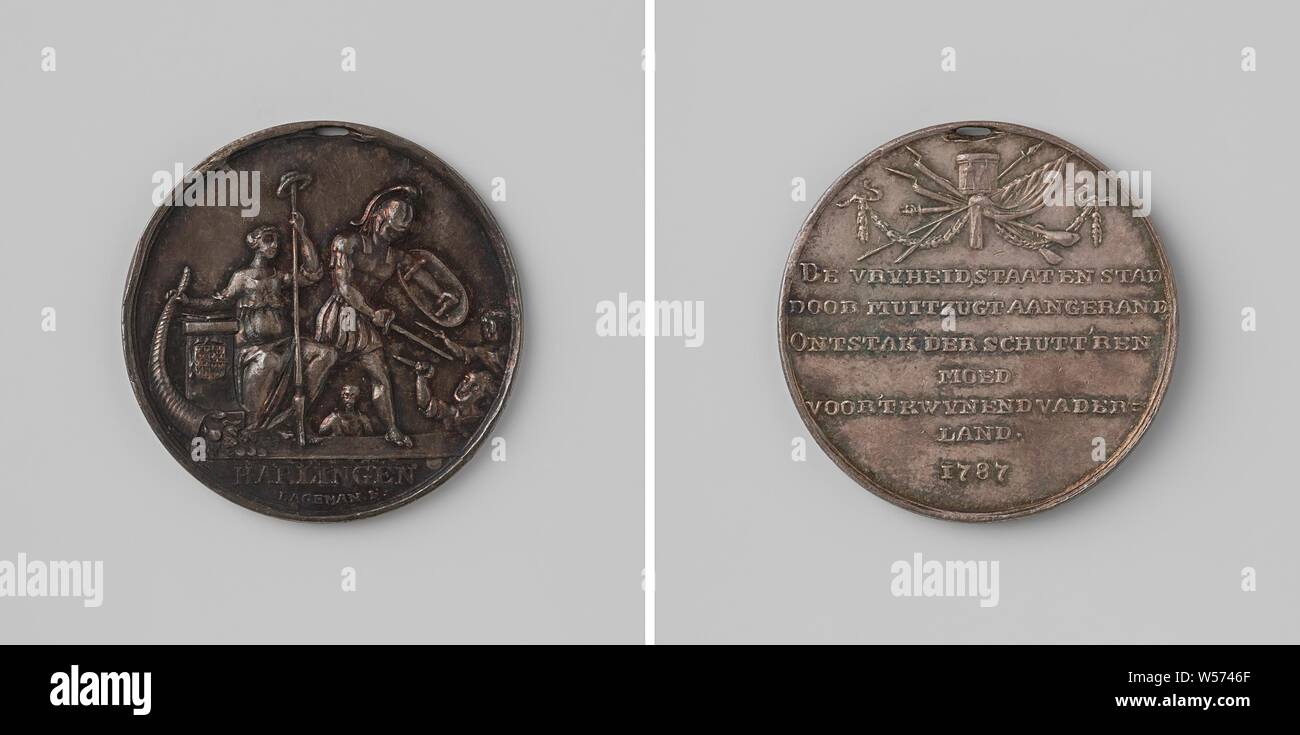 Stilling the riot in Harlingen, medal awarded to the shooters, Silver medal with hole in it. Front: Freedom with stuffed horn of abundance and freedom hat on spear, sits next to altar on which hangs coat of arms, soldier in Roman uniform defends her against upcoming enemies, cut off: inscription. Reverse: inscription under trophee, constructed from military equipment., Harlingen, Johannes Michiel Lageman, Amsterdam, 1787, silver (metal), striking (metalworking), d 3.2 cm × w 10.67 Stock Photo