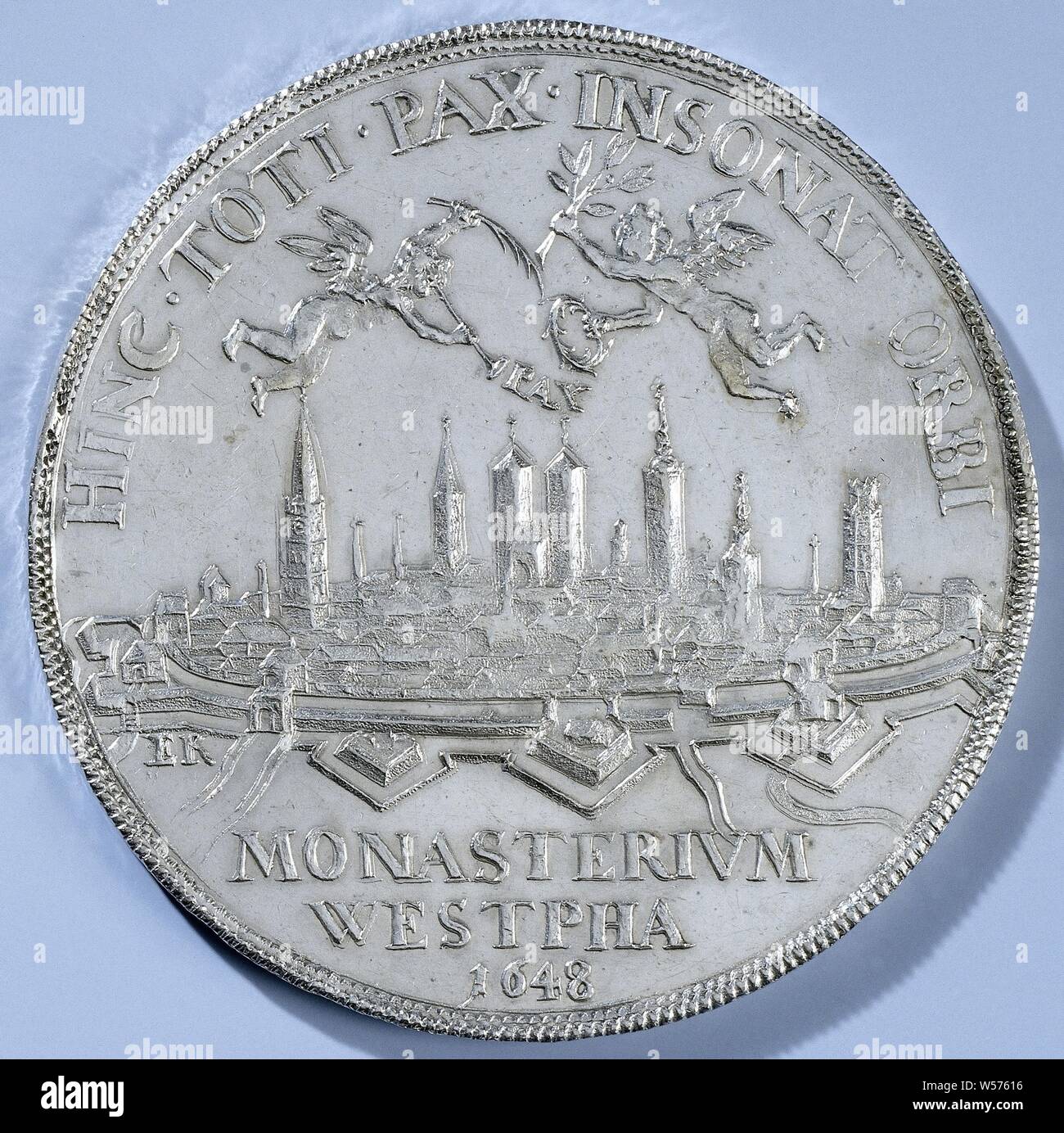 Peace of Munster, Silver Medal. Front: view of the city of Munster with above it two little angels with trumpet, palm branch, olive branch and laurel wreath inside inscription, above inscription. Reverse: two clenched hands between two horns of abundance and a pile of weaponry holding a branch of a branch of light, lit by the heavens and containing the name of Jehovah in Hebrew inside, Münster, North Rhine-Westphalia, Engelbert Kettler, 1648, silver (metal), striking (metalworking), d 5.2 cm × w 36.34 Stock Photo
