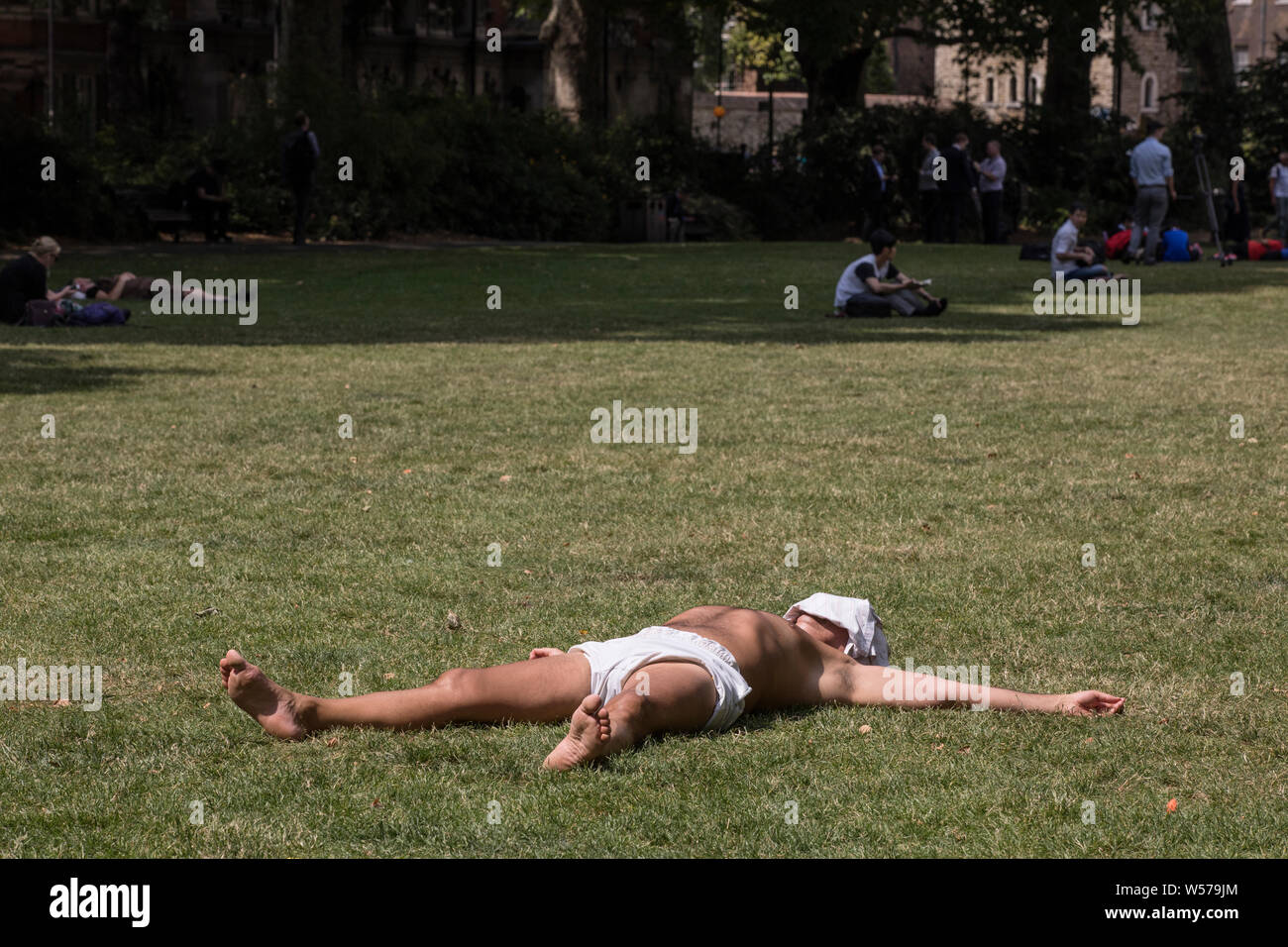 Man sunbathing in Victoria Tower Gardens, Westminster during the heatwave. Stock Photo