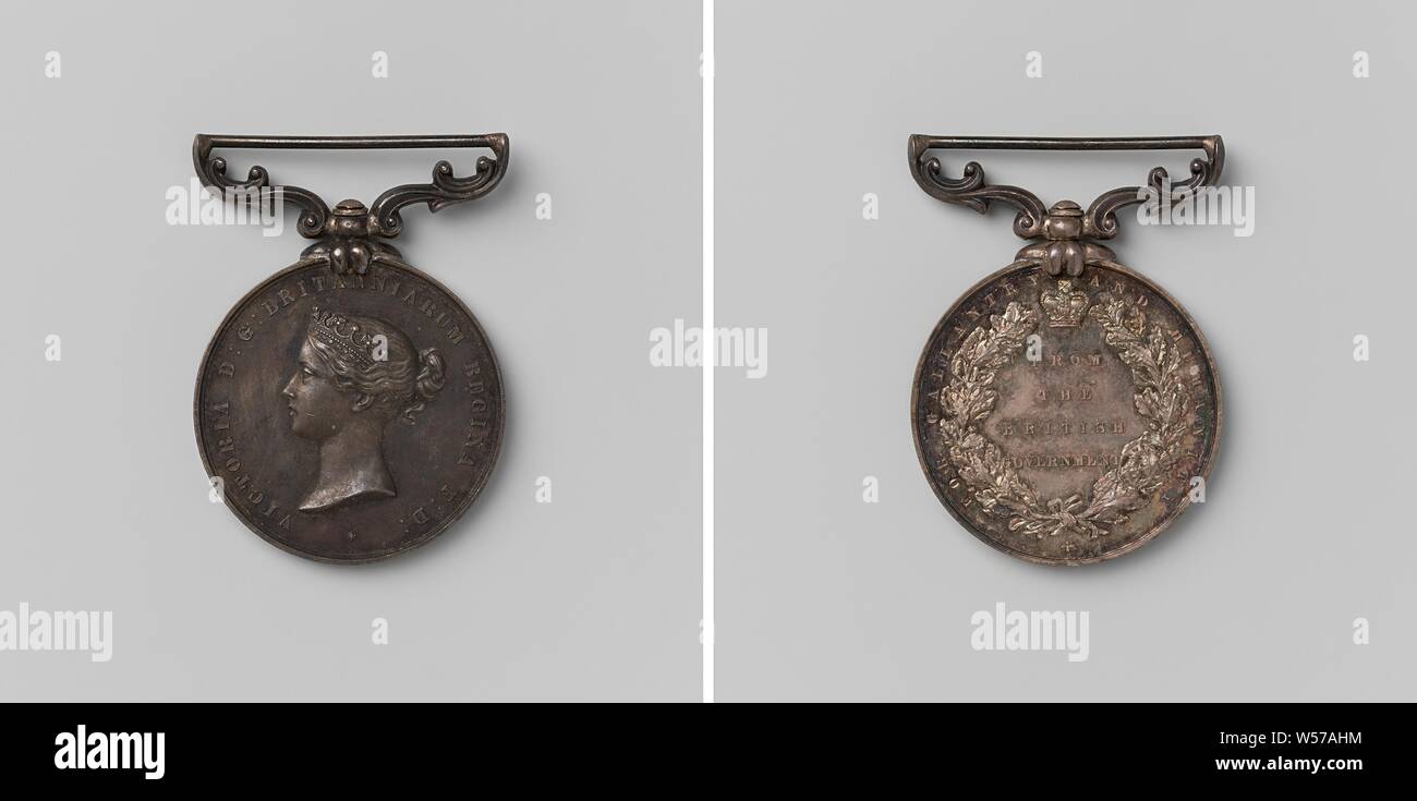 British government, medal awarded to Willem Broeks for charity, in honor of Victoria, queen of Great Britain, Silver medal on decorated, elongated pendant. Obverse: woman's bust inside the inside. Reverse: inscription under crown within oak wreath and inscription, lace lettering, Victoria (Queen of the United Kingdom and Empress of India), Willem Broeks, Leonard Charles Wyon, London, 1859, silver (metal), engraving, d 4.5 cm × d 3.2 cm × w 20.73 Stock Photo