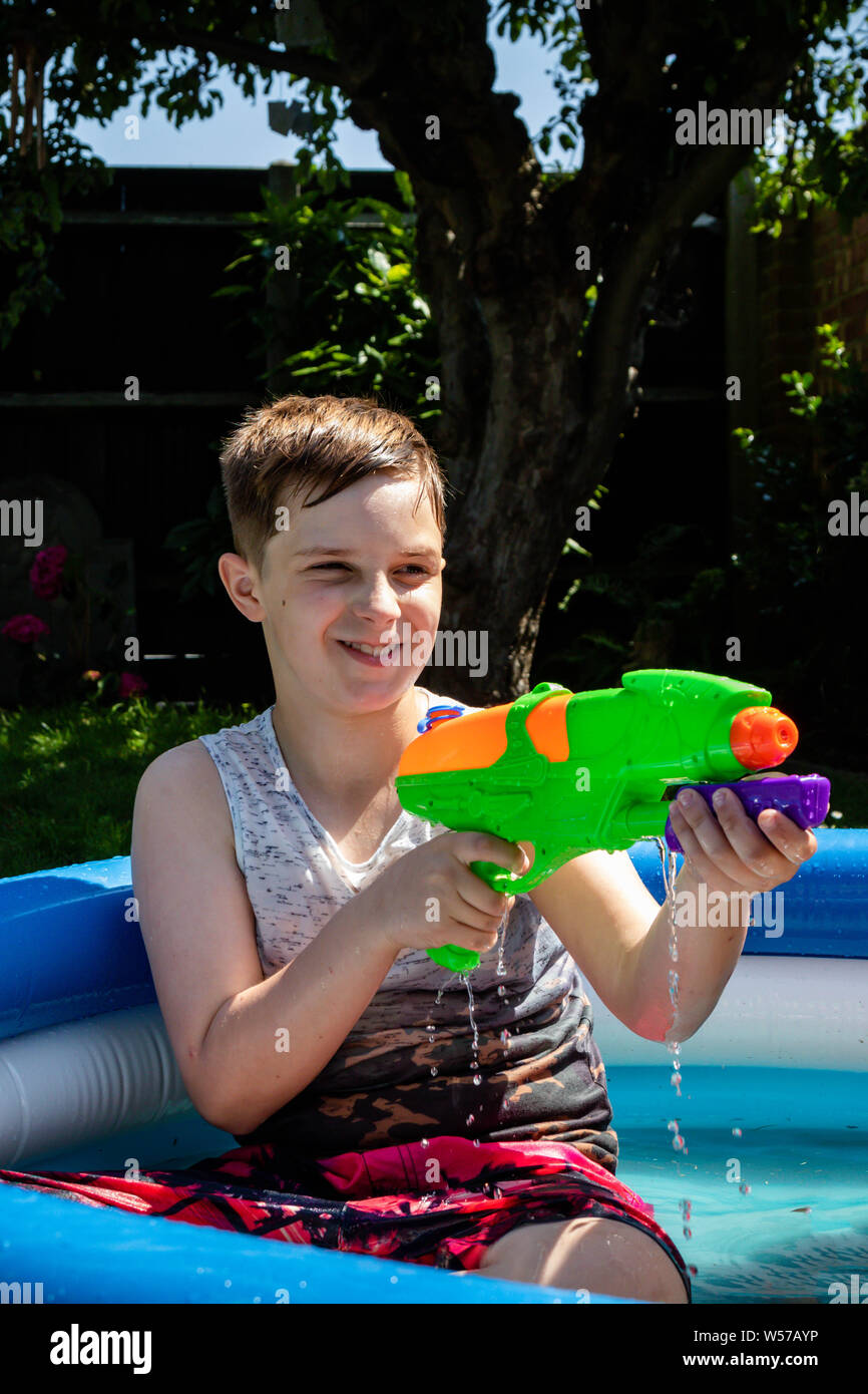 https://c8.alamy.com/comp/W57AYP/preteen-caucasian-boy-playing-wth-a-water-gun-on-a-hot-summers-day-W57AYP.jpg