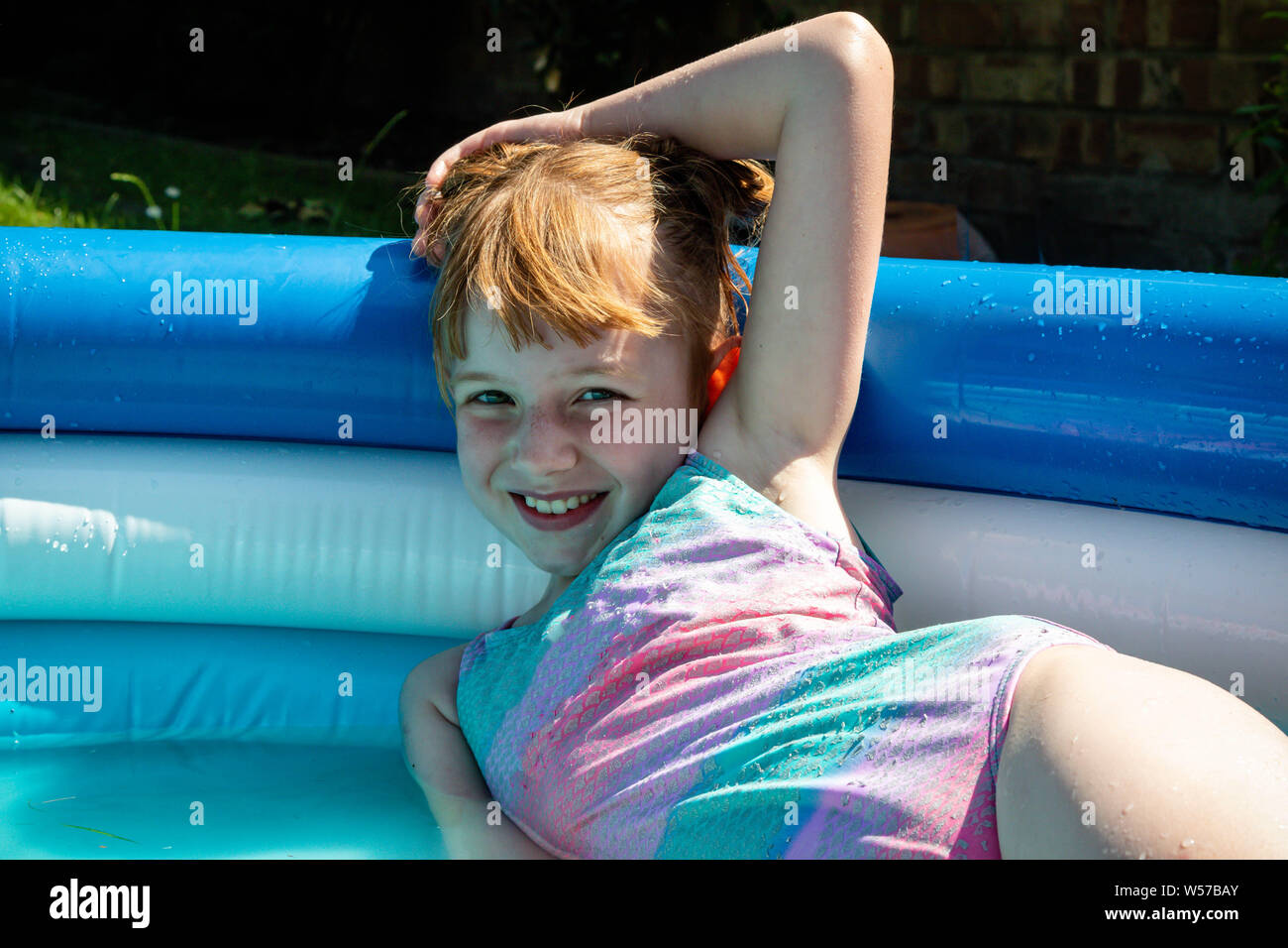 Preteen caucasian girl laying in a paddling pool Stock Photo Alamy