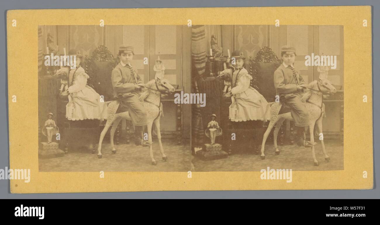Boy on a toy horse and a girl with a doll, (playing with) toys, (playing with) dolls, toy animals, Europe, anonymous, c. 1850 - c. 1880, cardboard, photographic paper, albumen print, h 85 mm × w 170 mm Stock Photo