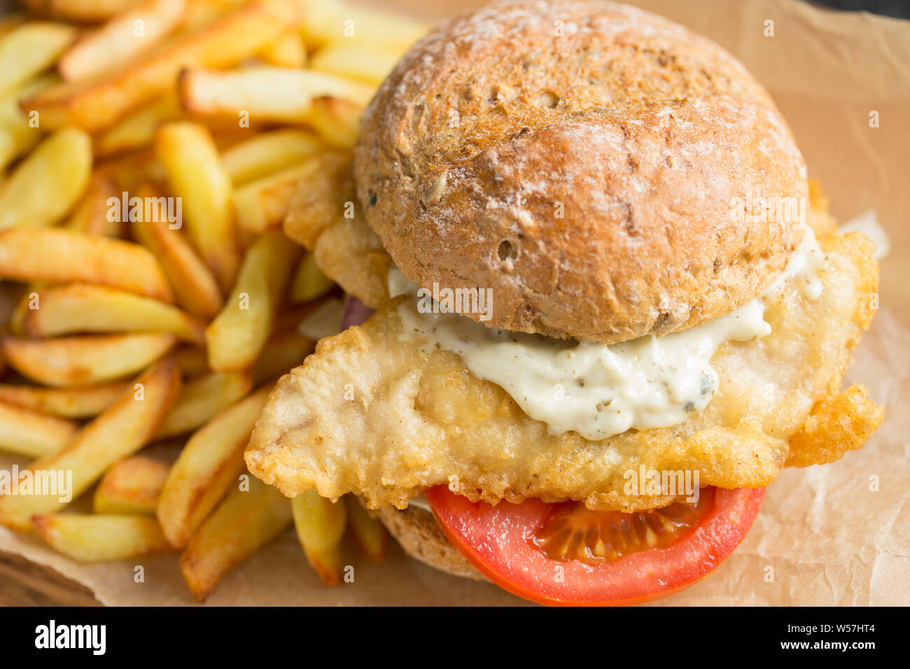 Two fillets of mackerel, Scomber scombrus, that have been dipped in flour and batter and deep fried to make a homemade mackerel burger. The mackerel w Stock Photo