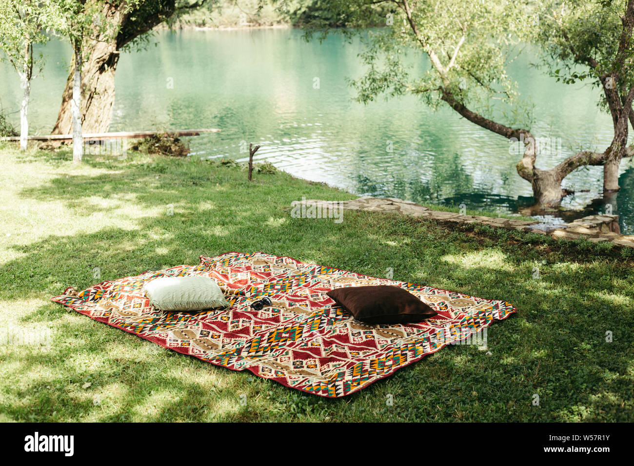 Colorful rug on grass near river Stock Photo Alamy