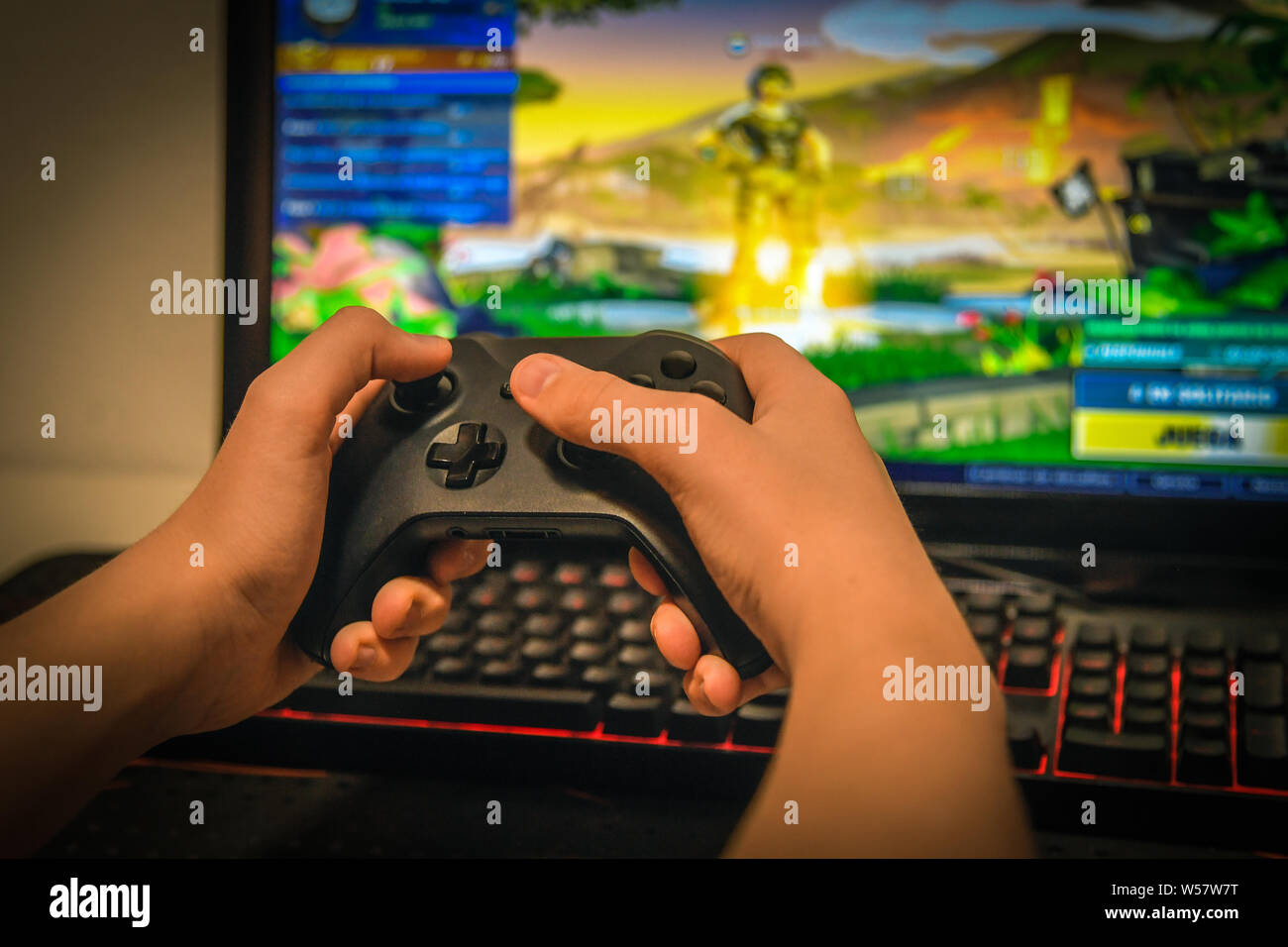 Young boy playing videogame on computer and having fun with a new game.  Child enjoy video games with wireless controller sitting at his desk fully  con Stock Photo - Alamy