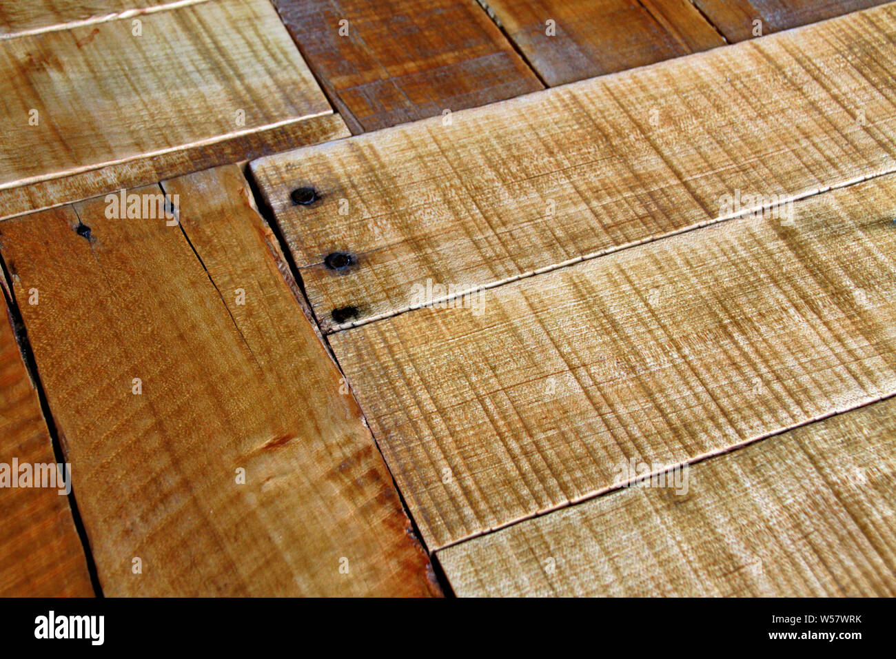 Part of a rough and rugged wood table top viewed at an angle. Stock Photo