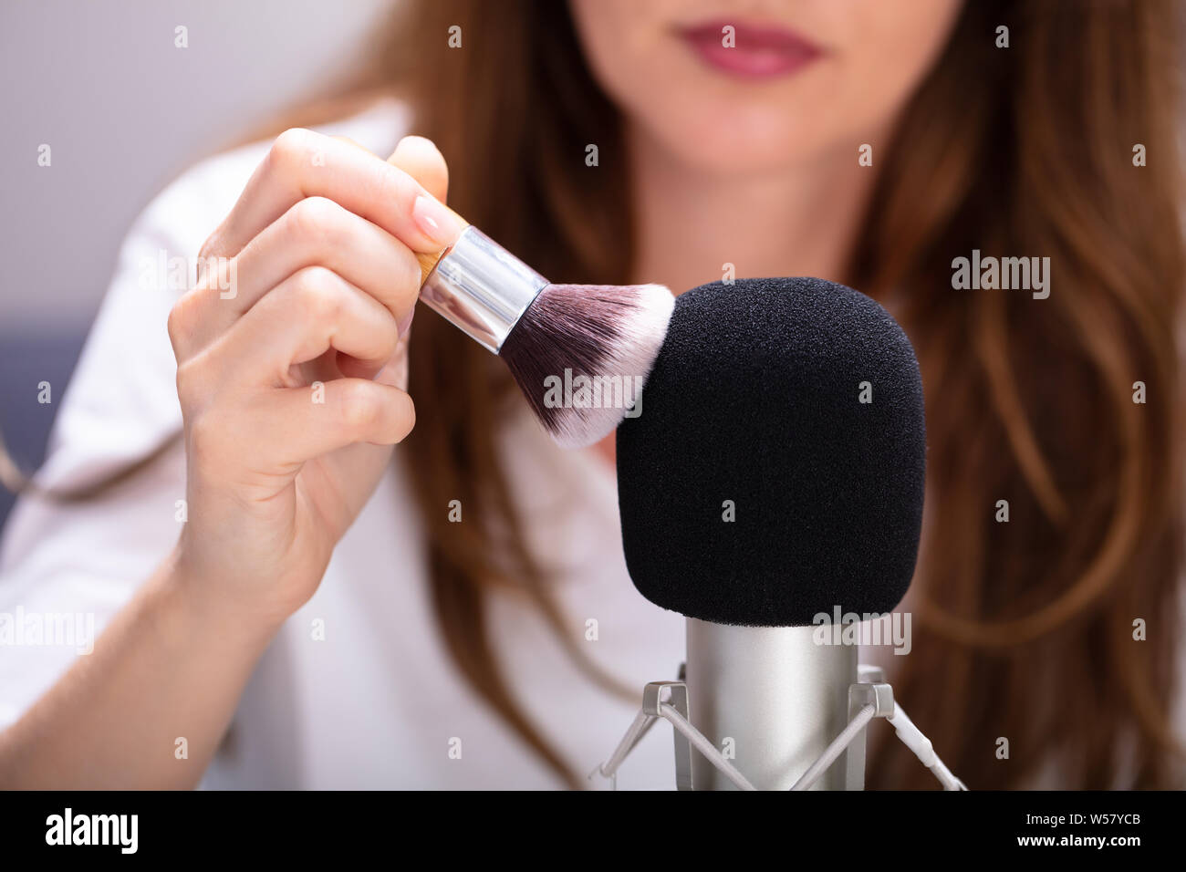 Woman using brush on microphone to make ASMR sounds Stock Photo Alamy