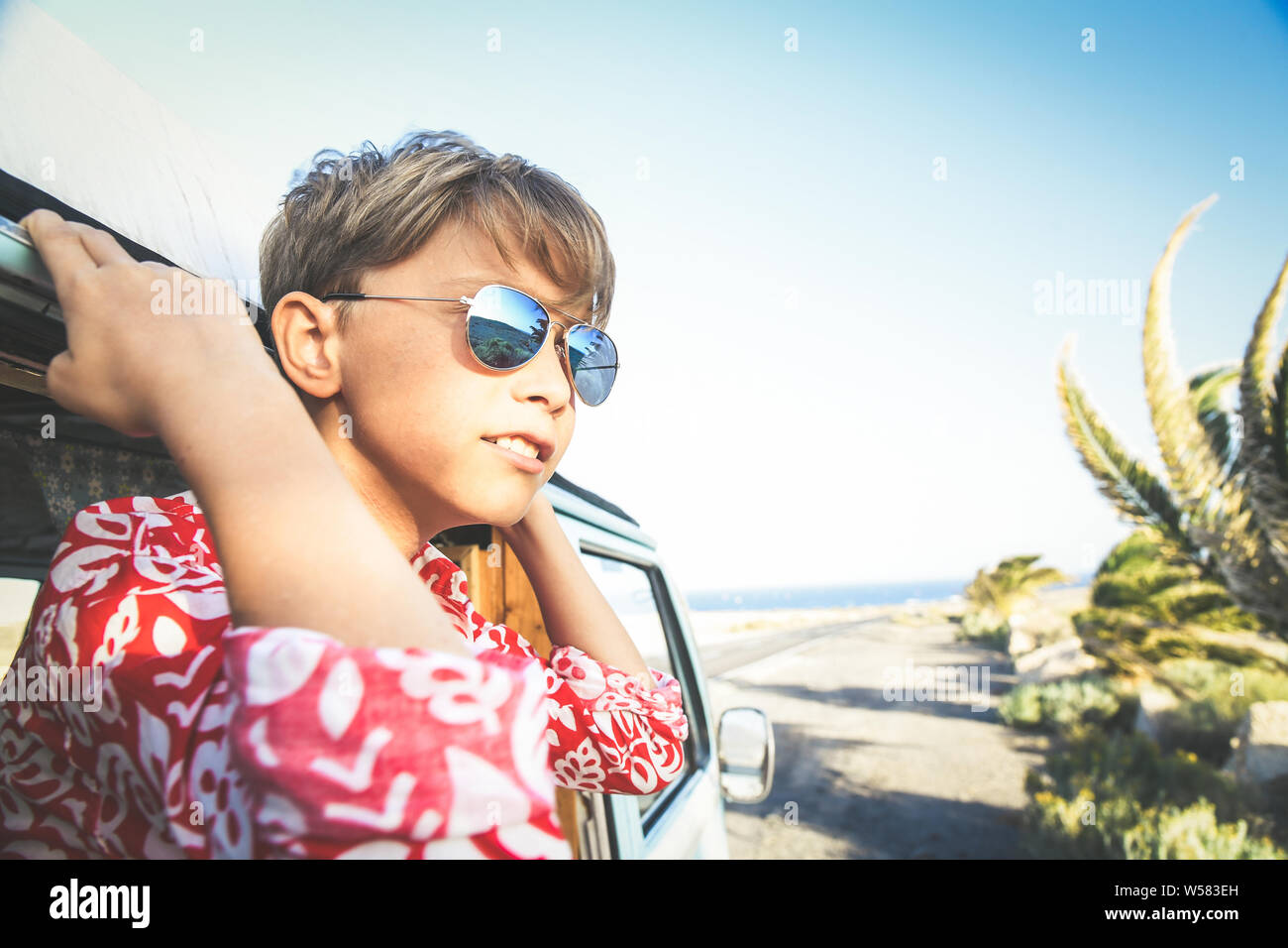 https://c8.alamy.com/comp/W583EH/handsome-teenage-boy-with-sunglasses-posing-charming-out-the-window-of-a-vintage-van-dressed-as-a-flower-hippie-child-concept-of-freedom-and-lighthea-W583EH.jpg