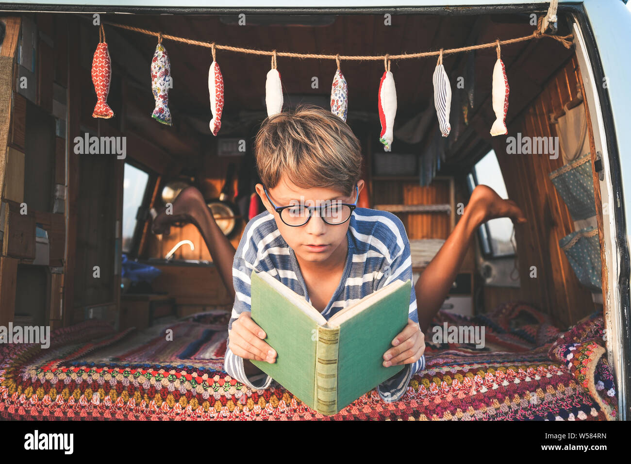 Young boy on retro mini van transport read a book Life inspiration concept with family minivan