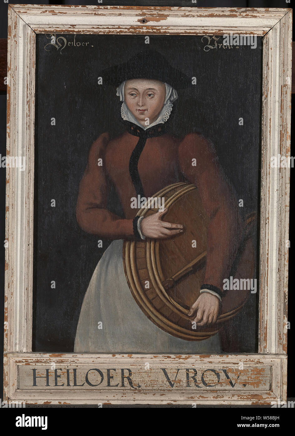 Heiloer Vrou, Old painting of a lady holding a wooden washbasin under her arm, Picture frame, h 52.5 cm × w 37.2 cm × d 2.9 cm h 42.2 cm × w 30.2 cm, ca. 16th century, oil on panel Stock Photo