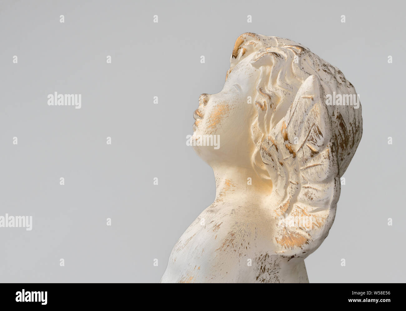 Statue of an angel on light grey background, vintage design. Space for text. Concept for religion, belief, love, hope and mourning. Stock Photo