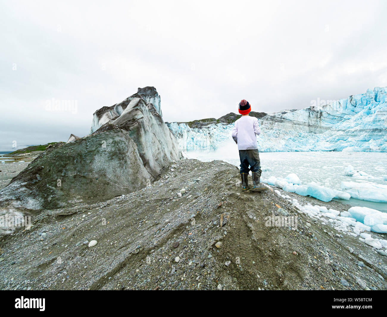 A young boy in front of Lamplugh Glacier, Glacier Bay National Park and Preserve, Alaska, USA. Stock Photo