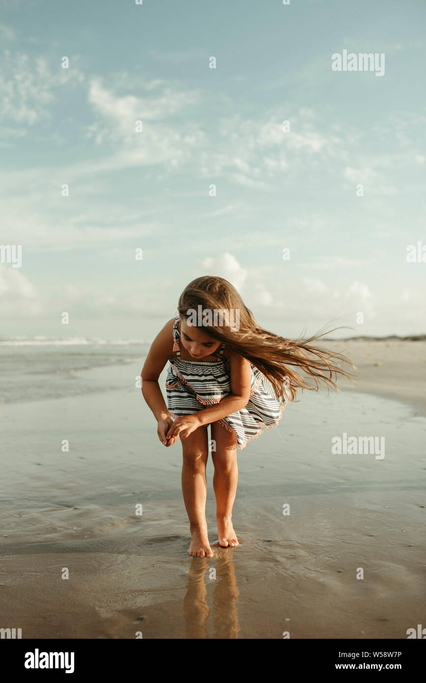 Little Girl looking for shells on the beach in Corpus Christi Texas