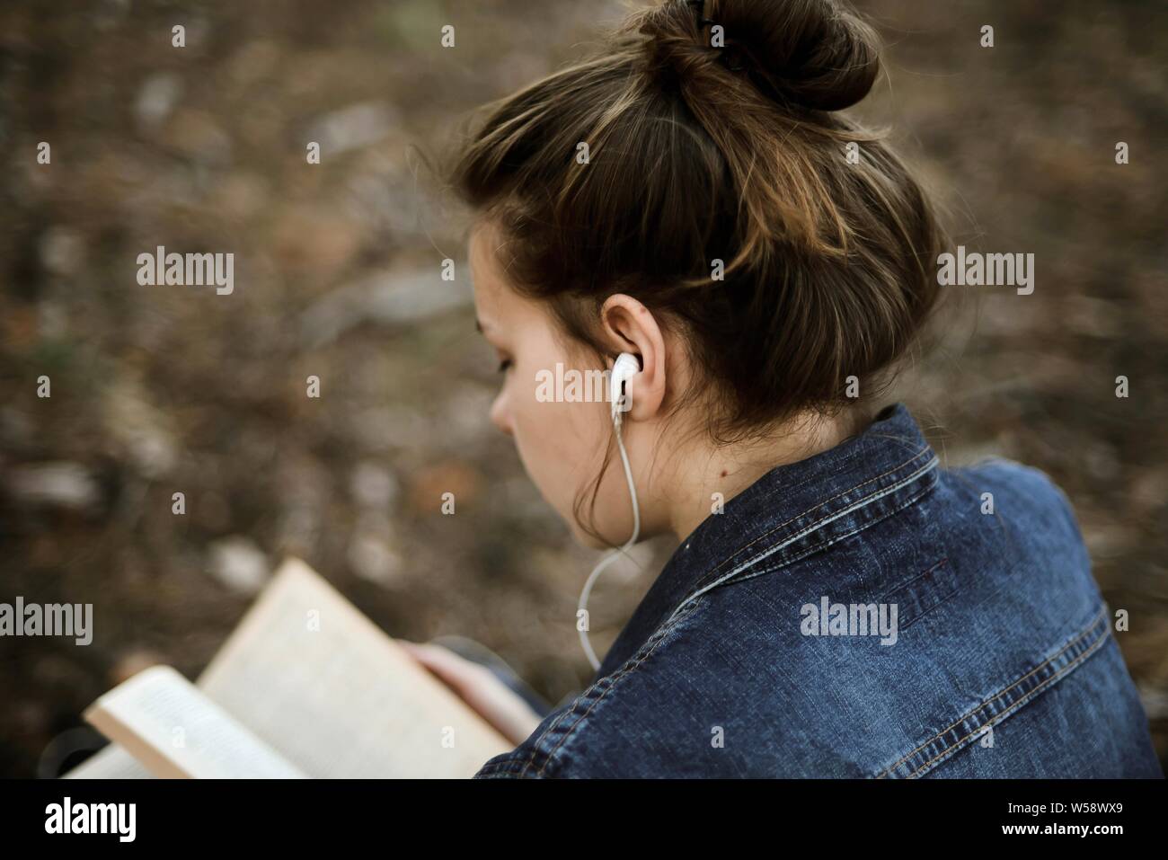 Woman reading a book sitting in the forest Stock Photo