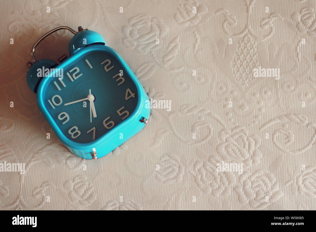 Blue alarm clock above the bed Stock Photo Alamy