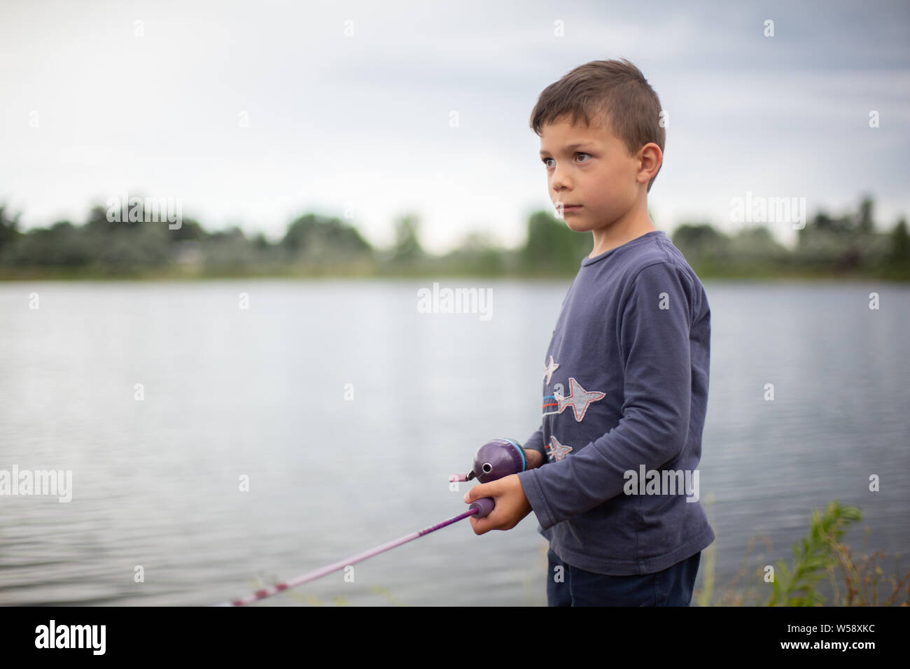 Boy playing with fishing pole hi-res stock photography and images - Alamy