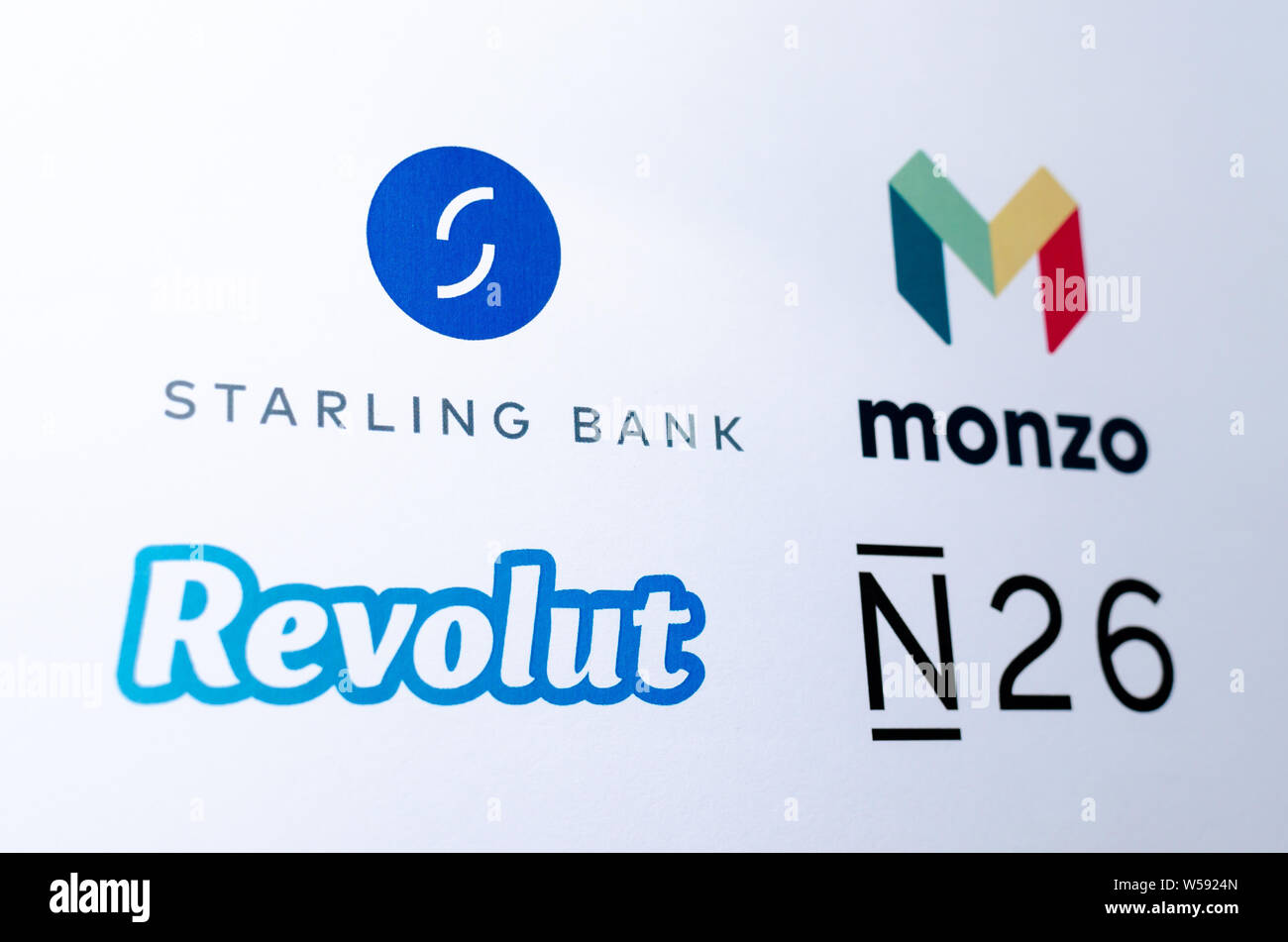 Logos of competing fintech companies that represents virtual banks: Monzo, Revolut, Starling Bank, N26, Printed on paper. Stock Photo