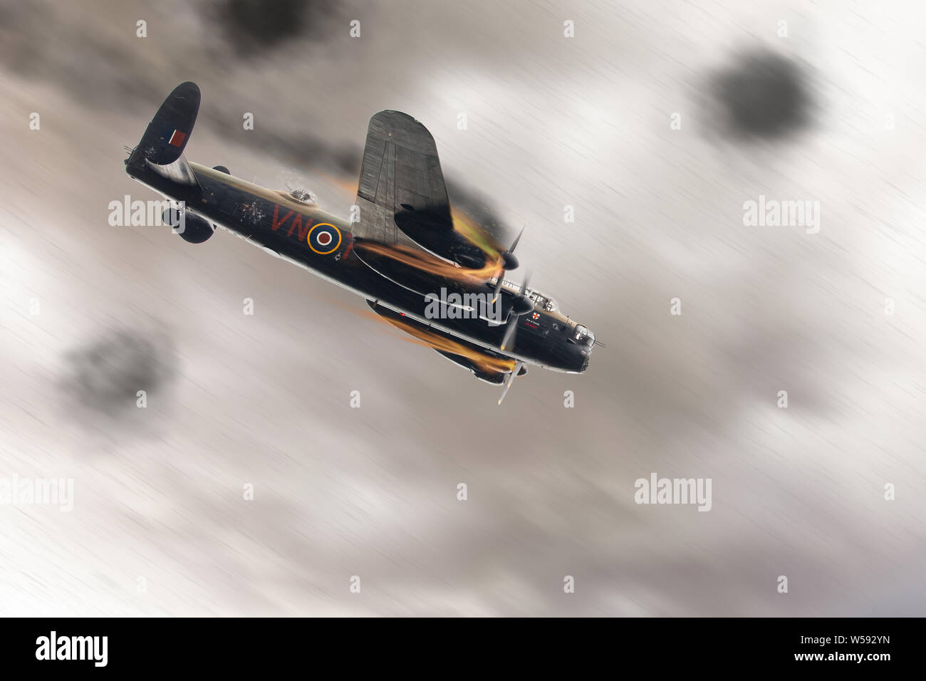 Lancaster bomber plane illustration shot down, smoking and on fire during a dog fight, crashing towards the ground at full speed.  Anti aircraft flak Stock Photo