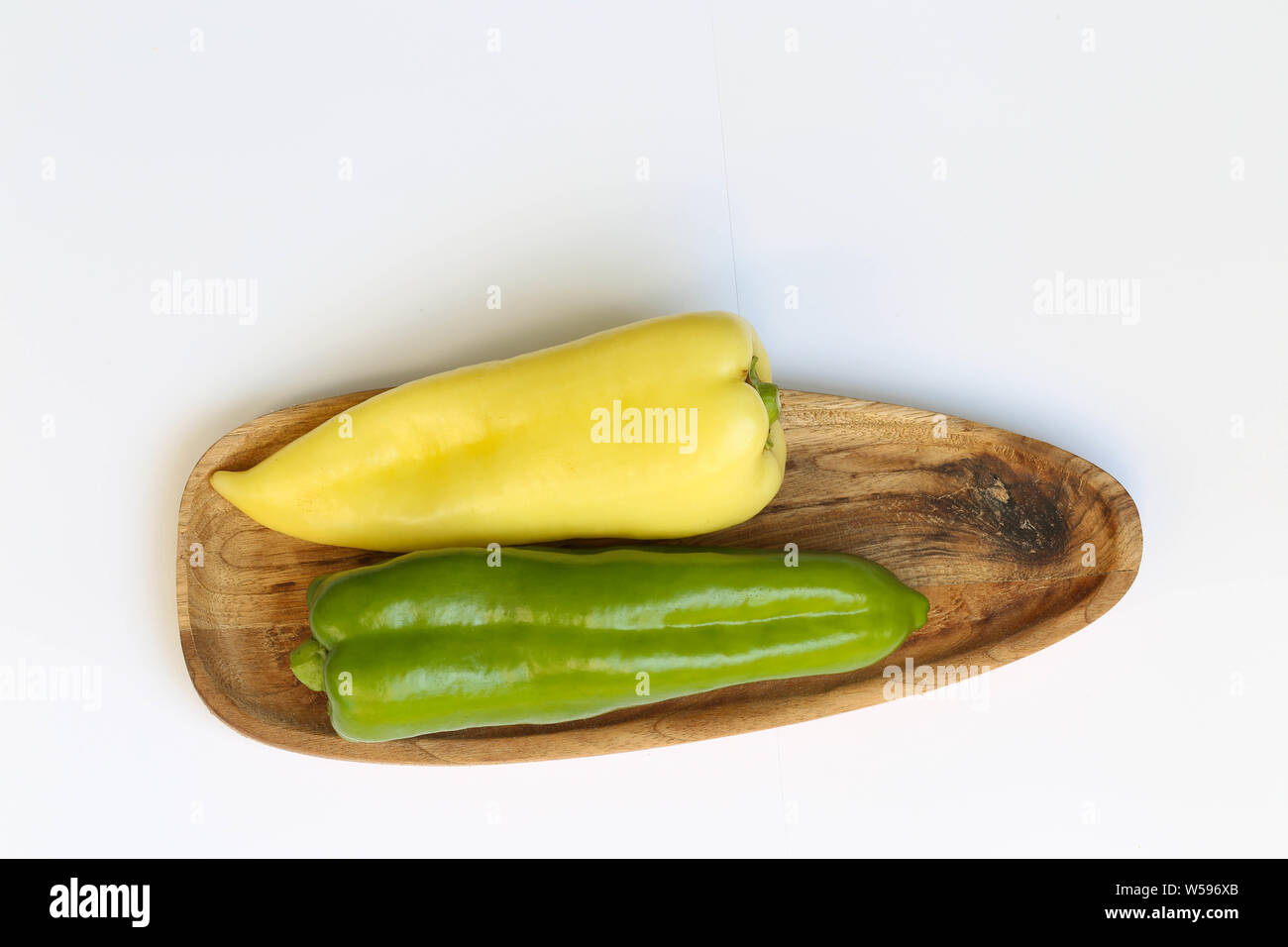 Grüner und gelber Paprika auf Holzbrett Stock Photo