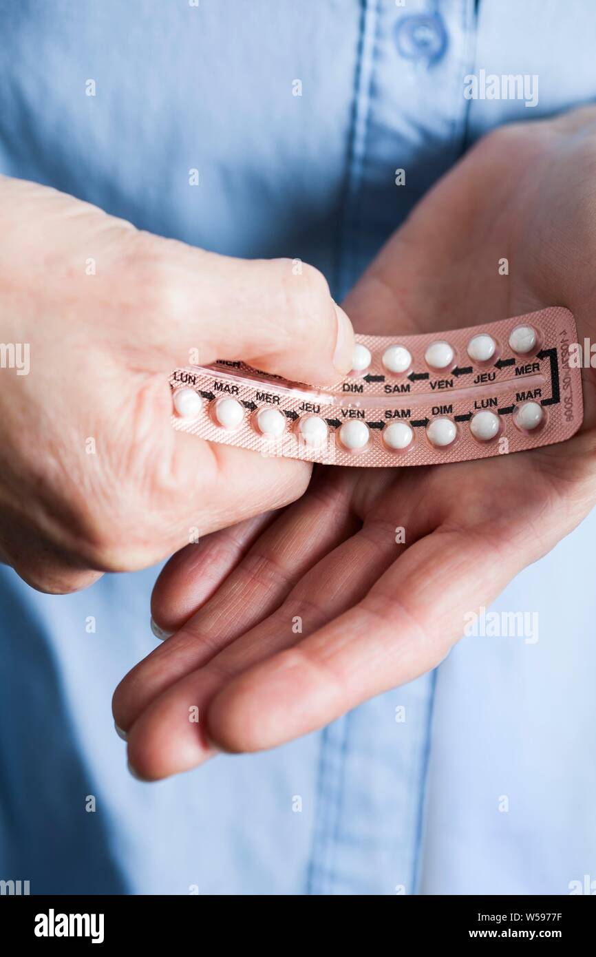 Hands holding hormone replacement therapy (HRT) pills. HRT pills are