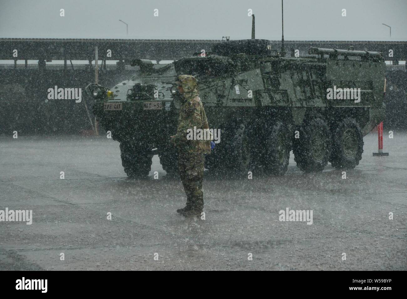A U.S. Army Soldier assigned to 2d Squadron, 2d Cavalry Regiment, waits to guide a 30mm cannon Stryker Infantry Carrier Vehicle - Dragoon out of the motor pool during Agile Spirit 19 in Senaki, Georgia, July 25, 2019, July 25, 2019. AS19 is a cooperatively led exercise between the Georgian Defense Forces, designed to support theater security cooperation and training efforts among the 14 allies and partnering nations participating. The exercise is designed to improve joint and multinational readiness, interoperability, mobility and posture of combat credible forces across the European theater s Stock Photo