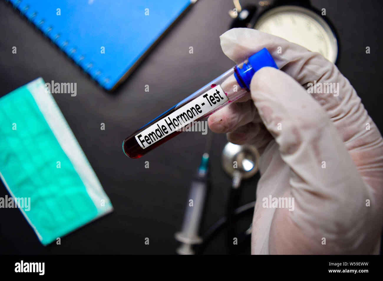 Female Hormone Test with blood sample. Top view isolated on black background. Healthcare