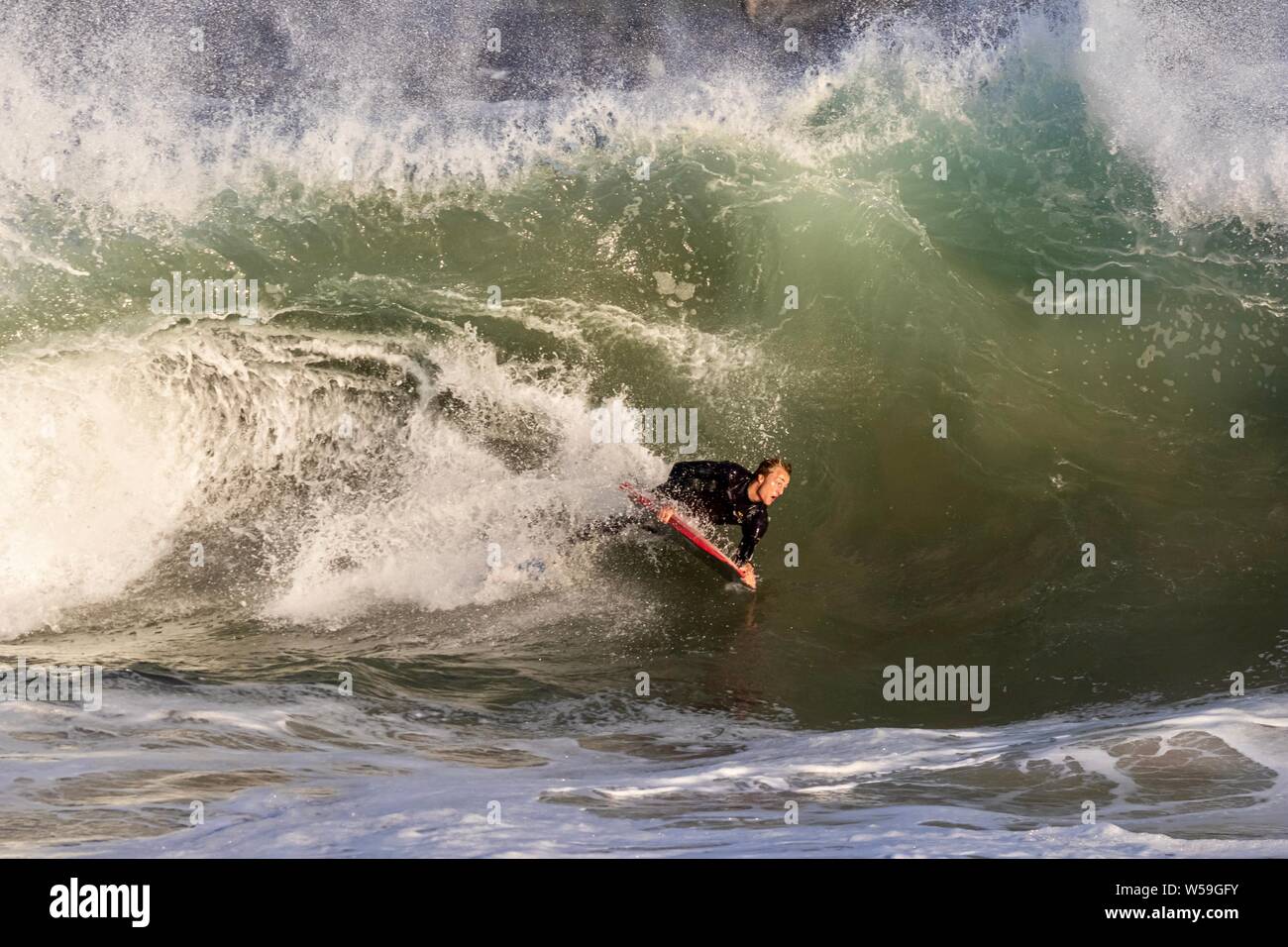 A bodyboarders surfing a large wave at The Wedge in Newport Beach