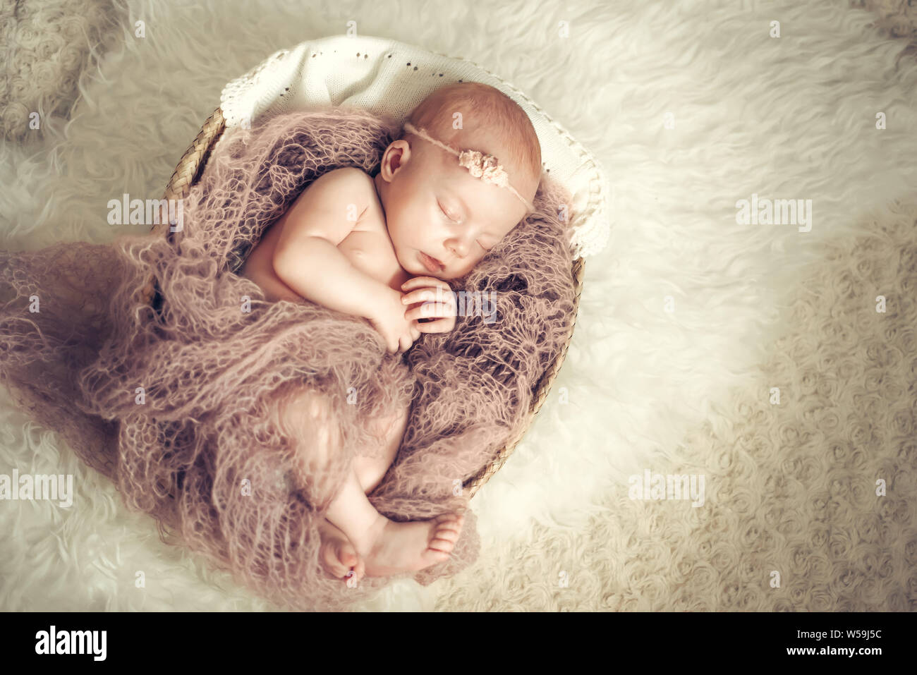 Newborn baby girl sleeping in a basket. Concept shooting newborns, innocence Stock Photo