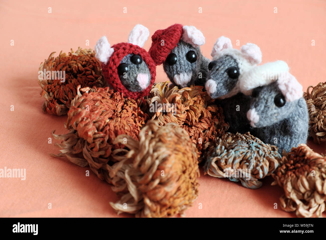 group cute mice stand on orange  background, woolen small rat knit from yarn in free time of craftsmanship Stock Photo