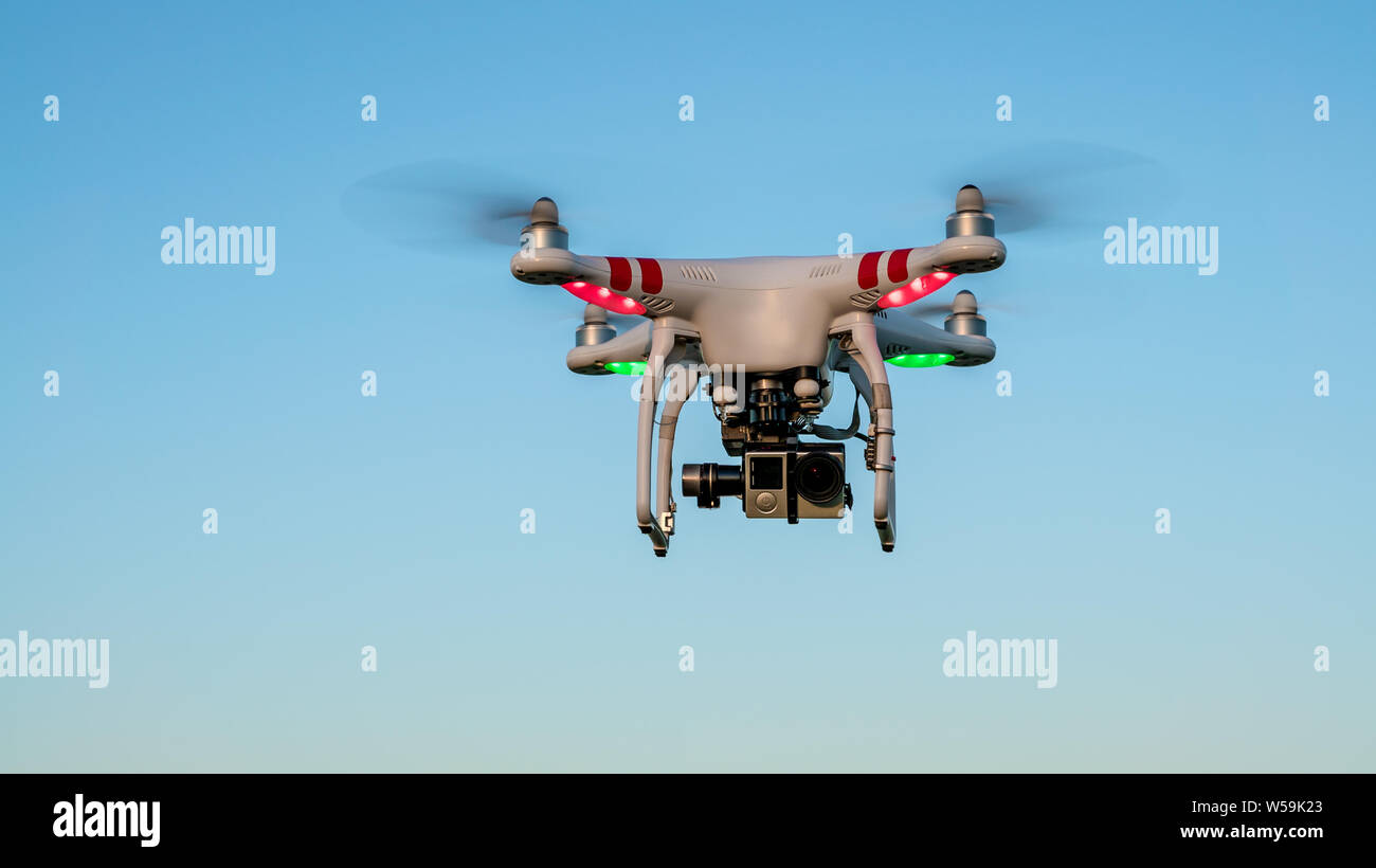 Drone flying with a digital camera and blue sky background. Modern new technology. Drone flying overhead takes aerials professional photos and video Stock Photo