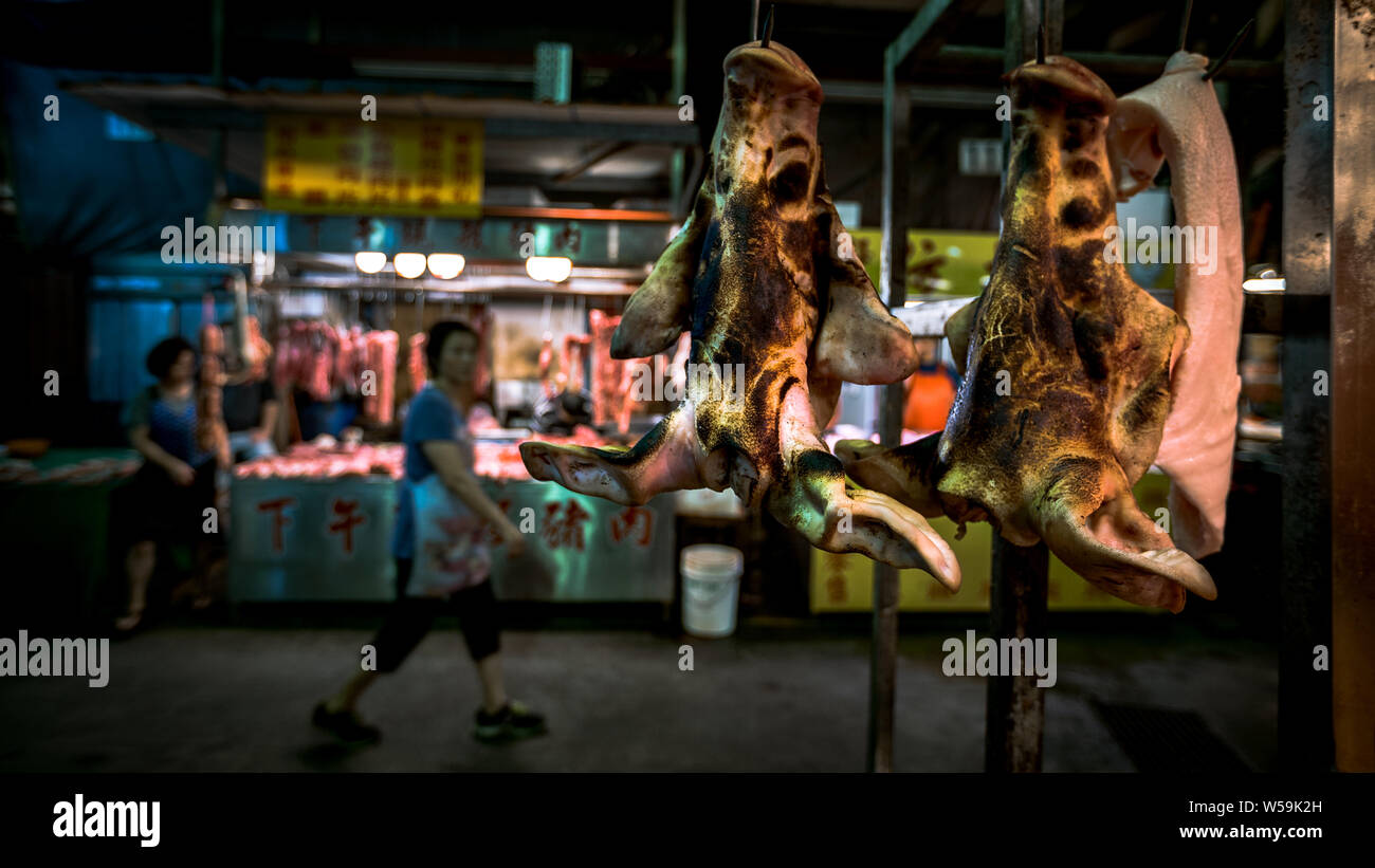 Raw pig face hanging on a hook. Traditional taiwanese food selding in a shop located at market of Taipei. Sale on market. Popular famous marketplace Stock Photo