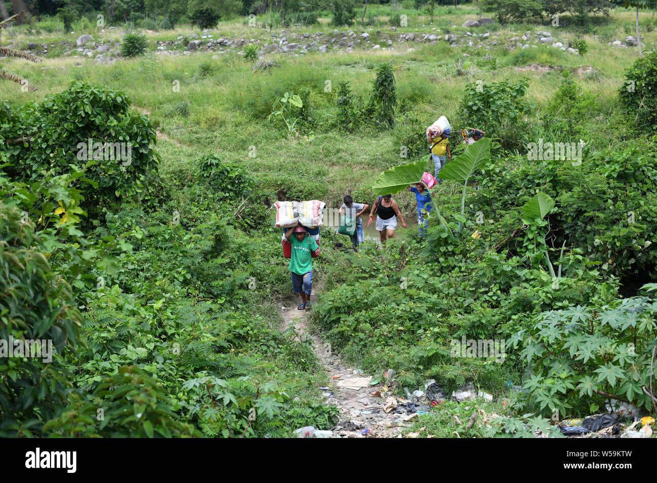 July 25, 2019, Talisman, Chiapas, Mexico: With the help of porters, Central American families and their pets cross into Mexican territory on Thursday, even as Guatemala signed a treaty with the Us designating it a 'safe'' country for migrants. Credit: Miguel Juarez Lugo/ZUMA Wire/Alamy Live News Stock Photo