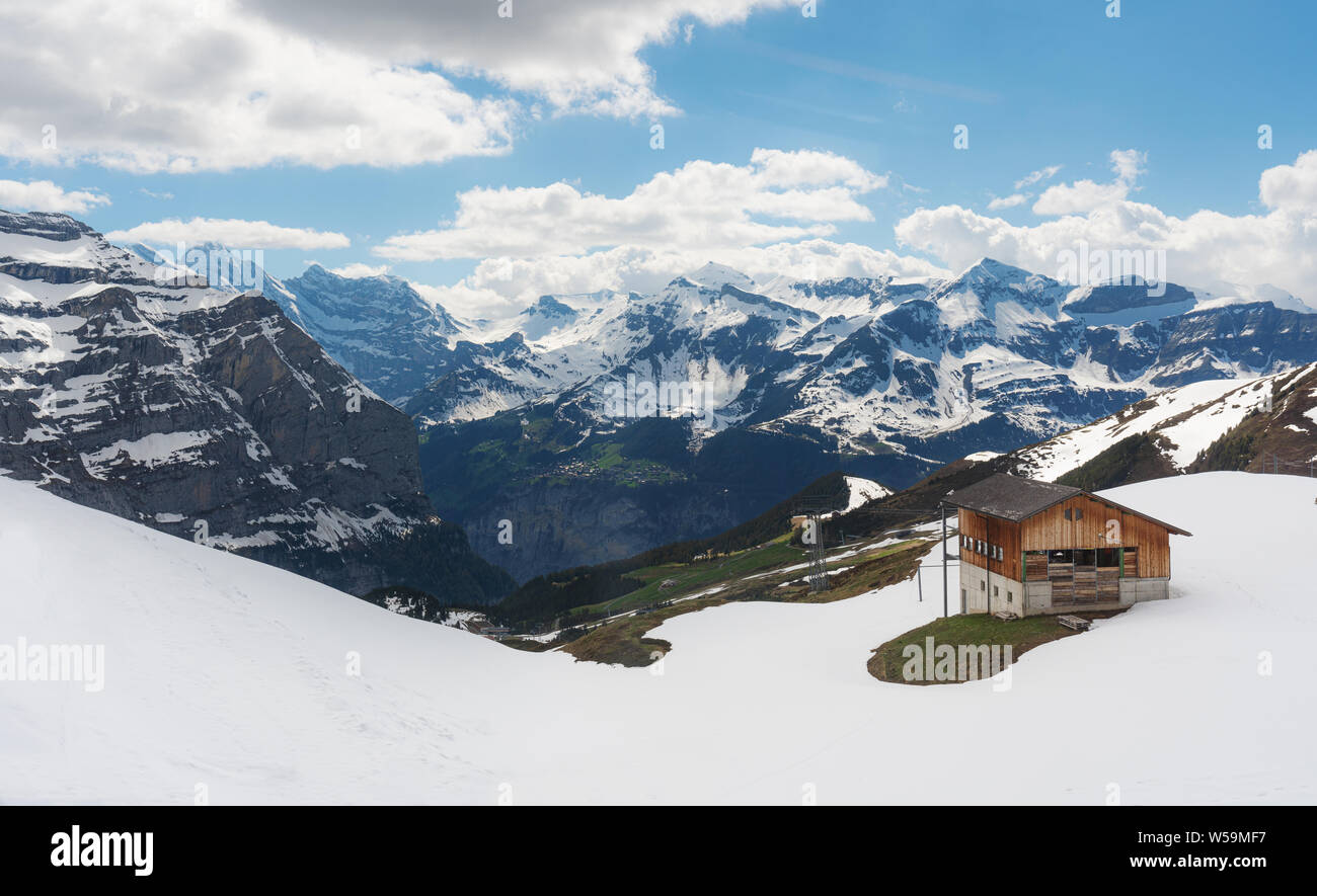 Panoramic Swiss Alps mountain range landscape with wooden cottage in Grindelwald, Switzerland Stock Photo