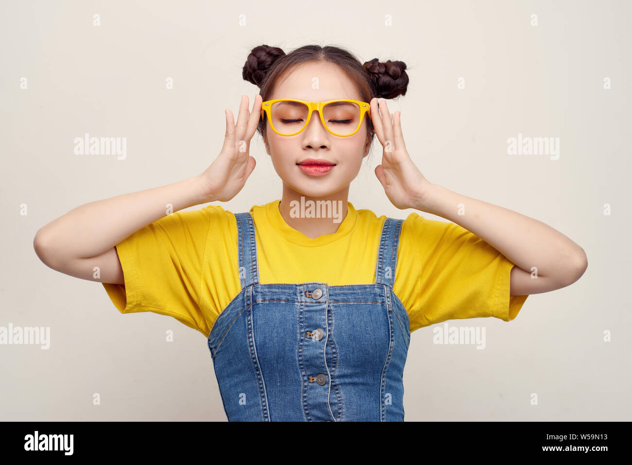 Beautiful Asian Woman Has Two Buns Of Hair Wearing A Jeans