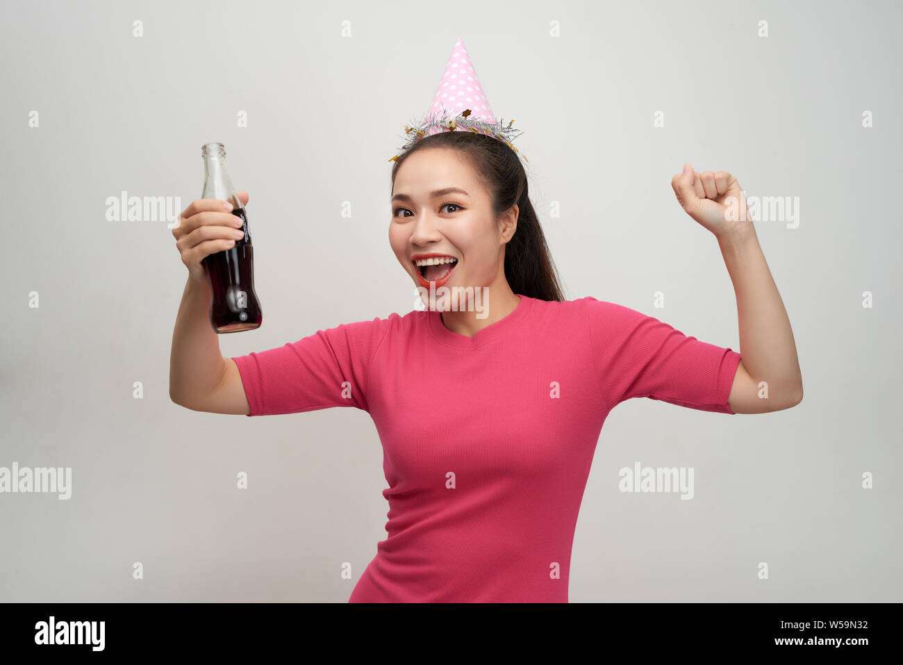 Stylish asian woman drinking soda dancing over white background Stock Photo