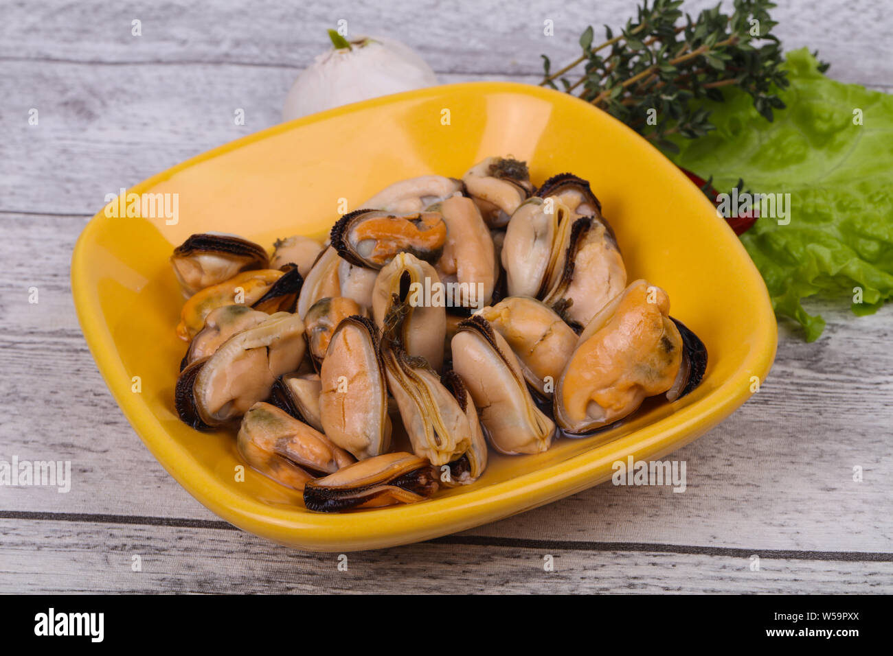 Pickled mussels in the bowl served pepper, garlic and salad leaves Stock Photo Alamy