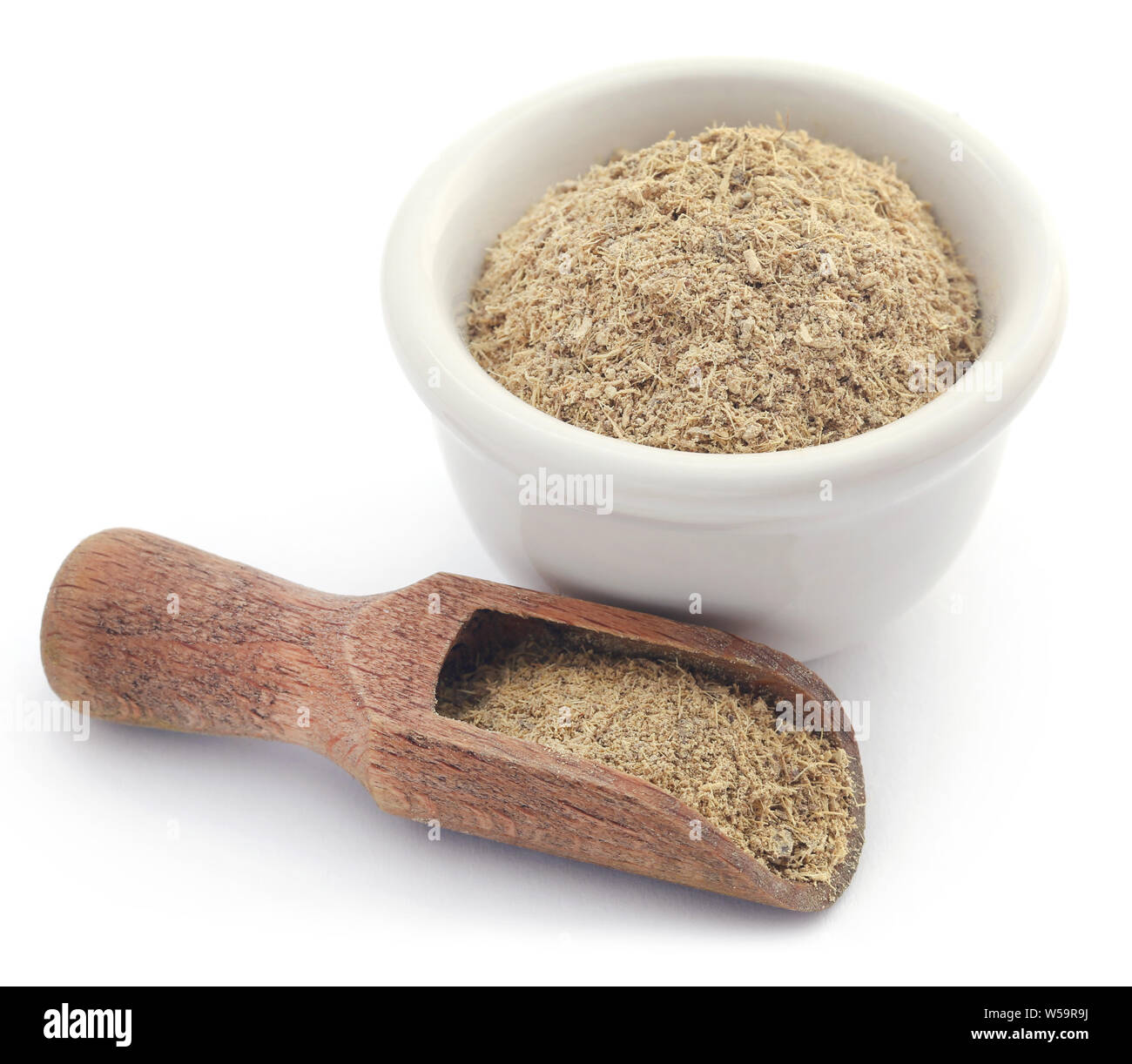 Liquorice stick and ground in a small bowl over white background Stock Photo