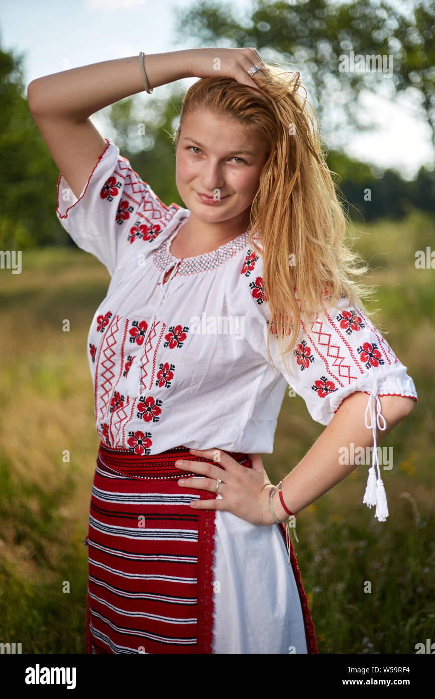 Portrait of a Romanian girl in traditional costume in an oak forest Stock Photo