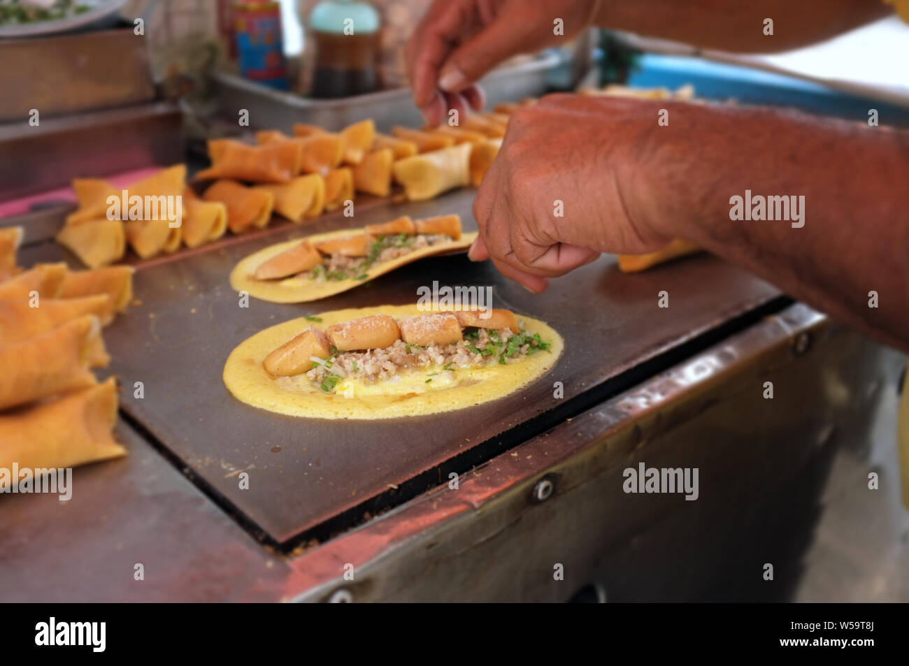 The man cooking Soft Waffle ,  Roll pancake stuffed with pork with custard and eeg ,Thai dessert. Stock Photo