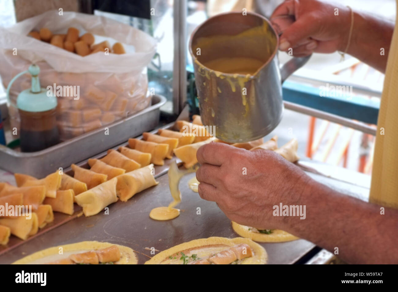 The man cooking Soft Waffle ,  Roll pancake stuffed with pork with custard and eeg ,Thai dessert. Stock Photo