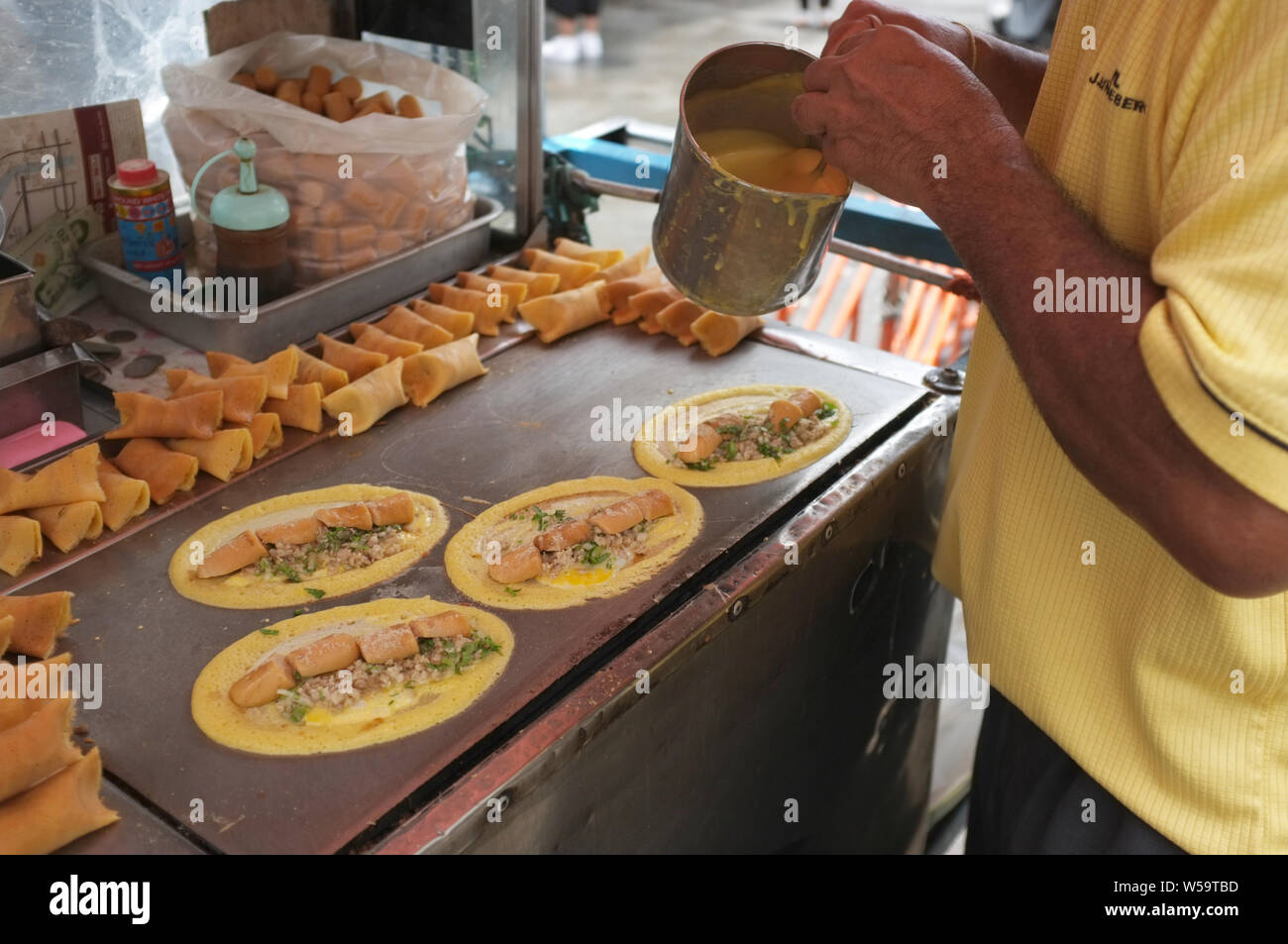 The man cooking Soft Waffle ,  Roll pancake stuffed with pork with custard and eeg ,Thai dessert. Stock Photo