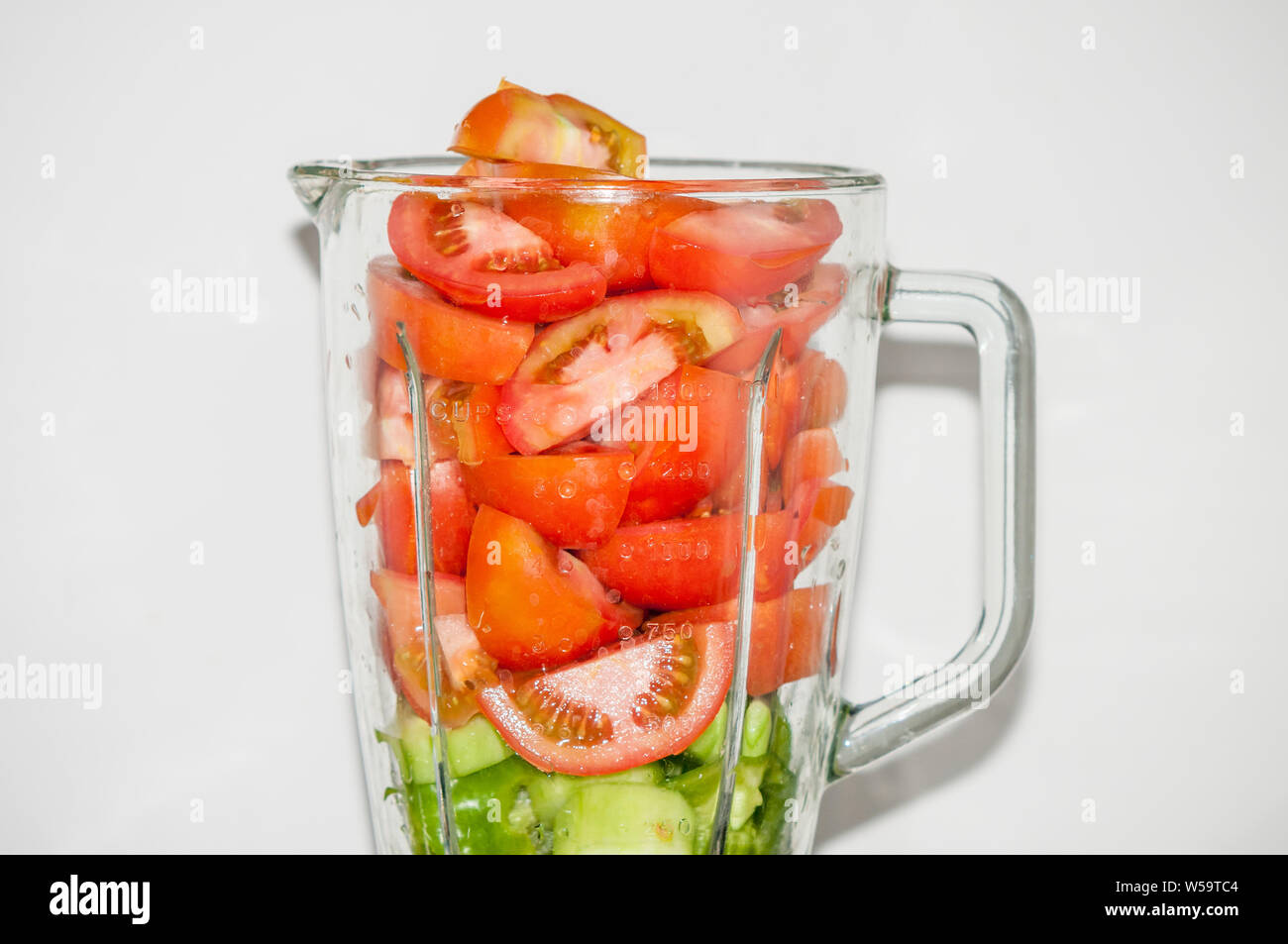 ingredients to make gazpacho in a food processor, tomato, cucumber and