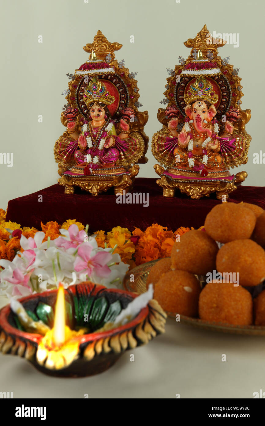 Sculpture of Lakshmi and Ganesha with sweets Stock Photo - Alamy