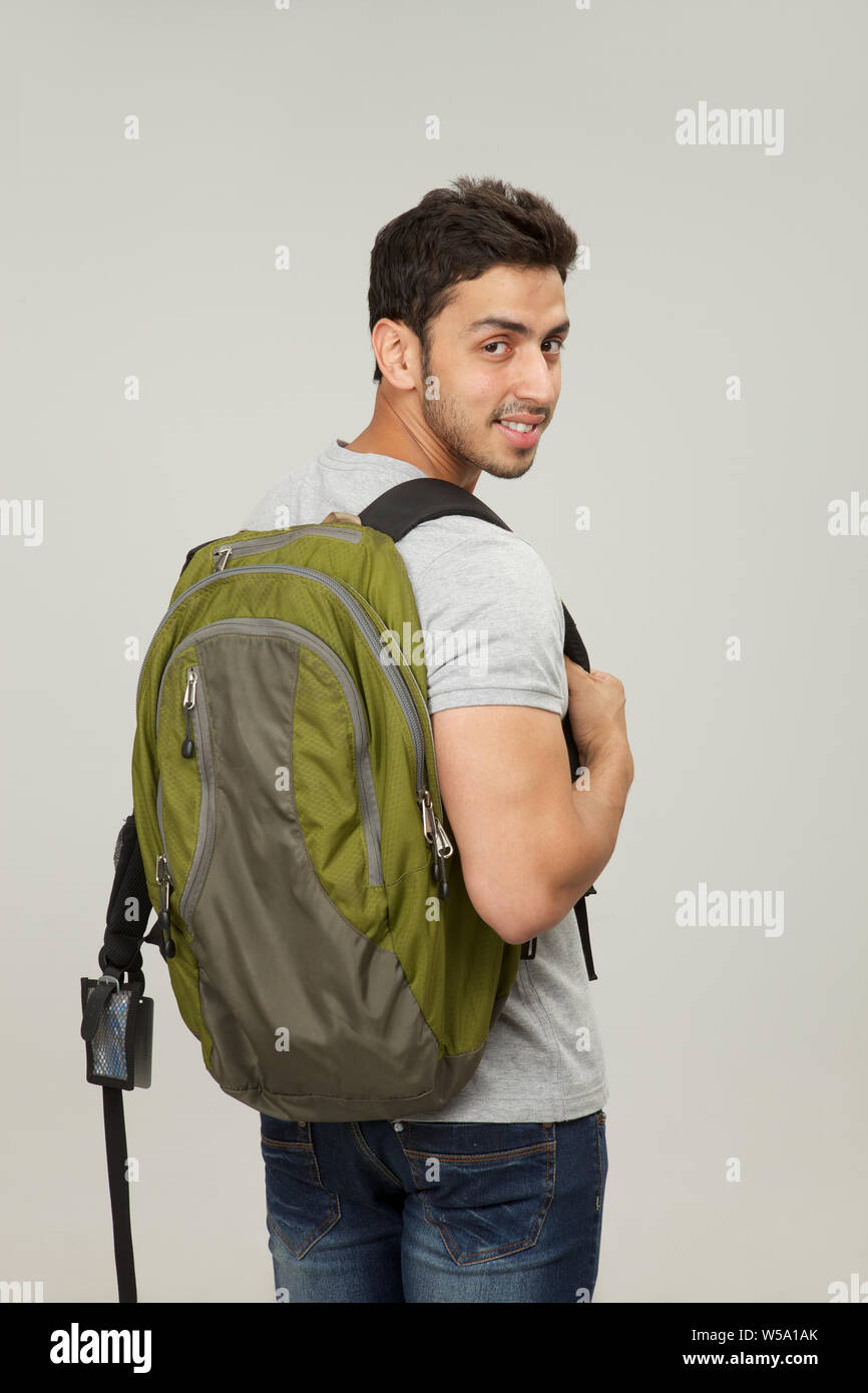 College student carrying a backpack and smiling Stock Photo Alamy