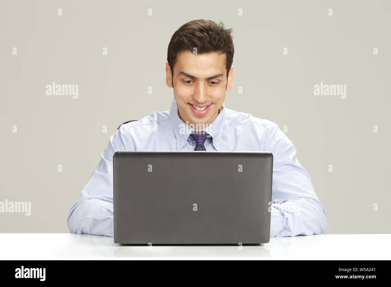 Businessman working on a laptop and smiling Stock Photo