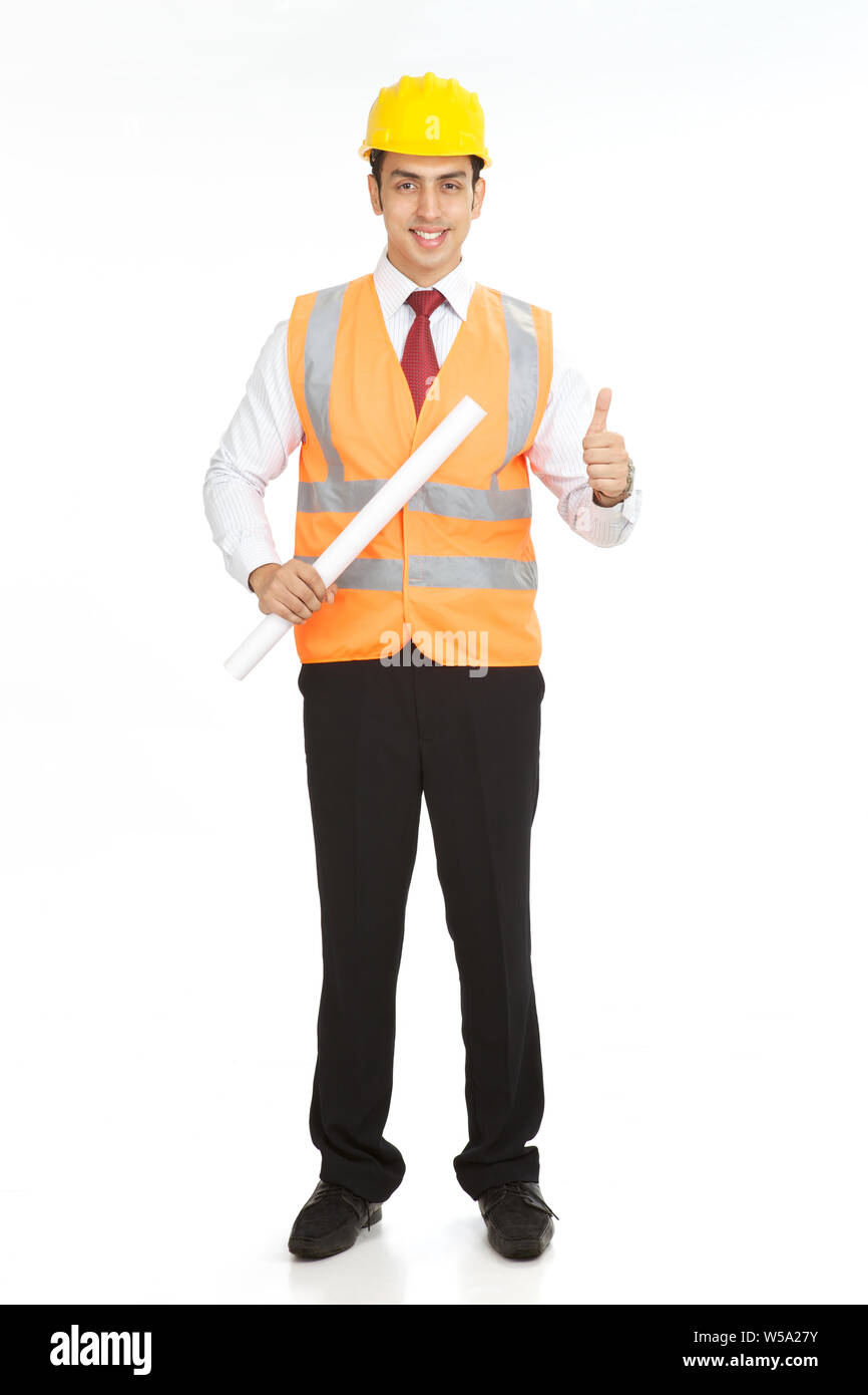 Male architect holding a blueprint and showing thumbs up sign Stock Photo