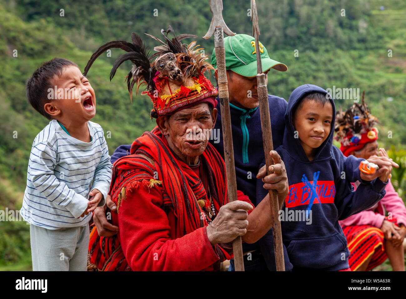 A Filipino Family Including A Frightened Child Pose With An Ifugao Tribesman, Banaue, Luzon, The Philippines Stock Photo